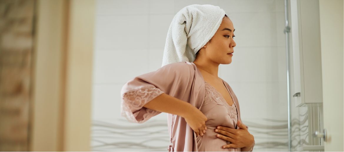 woman in robe doing a breast exam