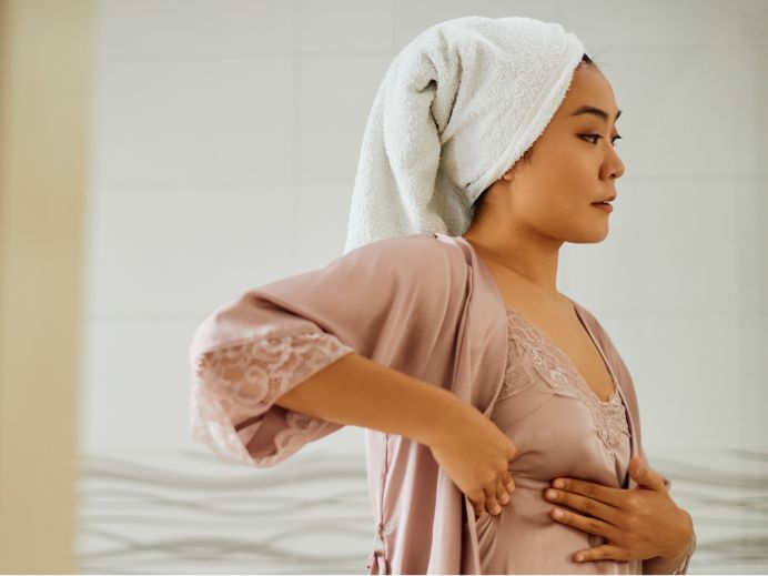 woman in robe doing a breast exam
