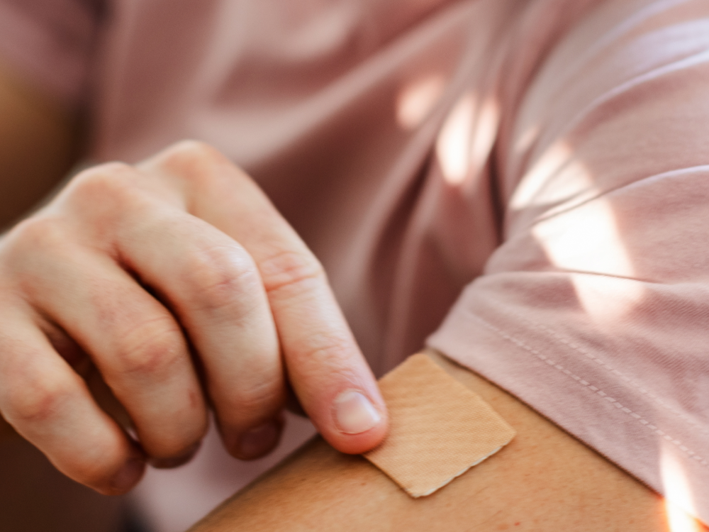 Male placing a nicotine patch on his arm