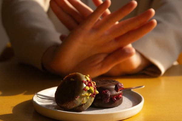 female hands blocking dessert signling a good health choice 