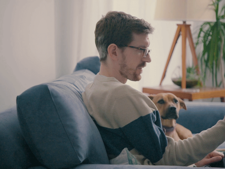 Keegan on couch with dog, video chatting