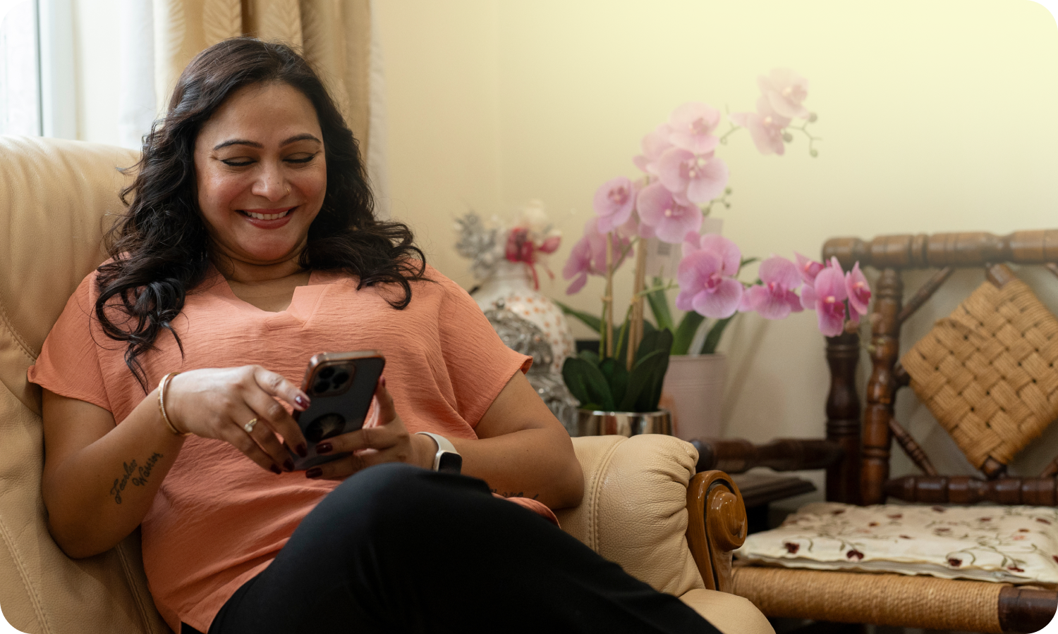 Female sitting on couch looking at her phone smiling 