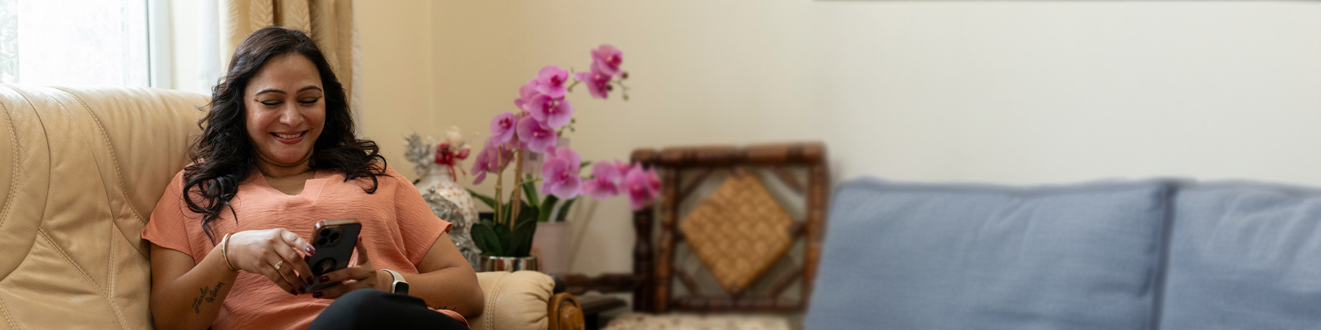 woman smiling, sitting on her couch
