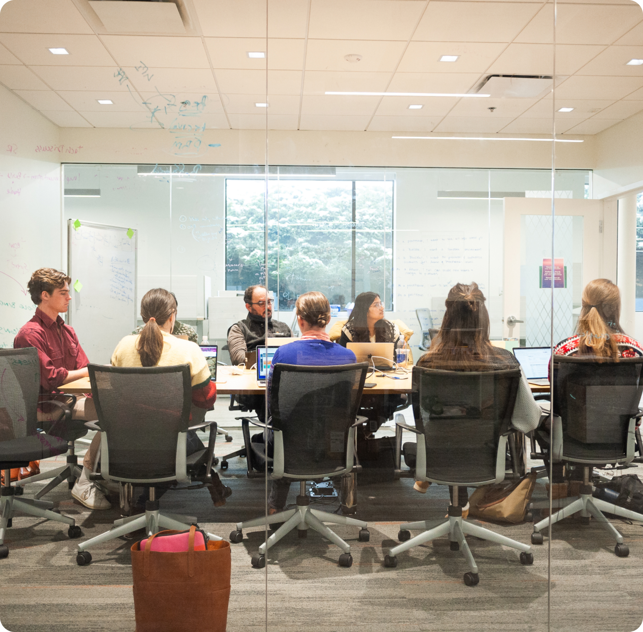 Large group of firefly employees in a meeting around a conference table 