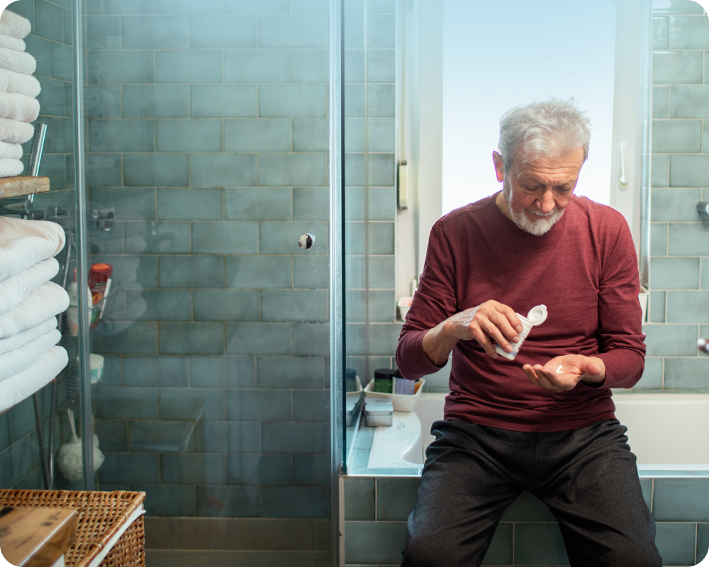 photograph of a man in the bathroom taking medicine 