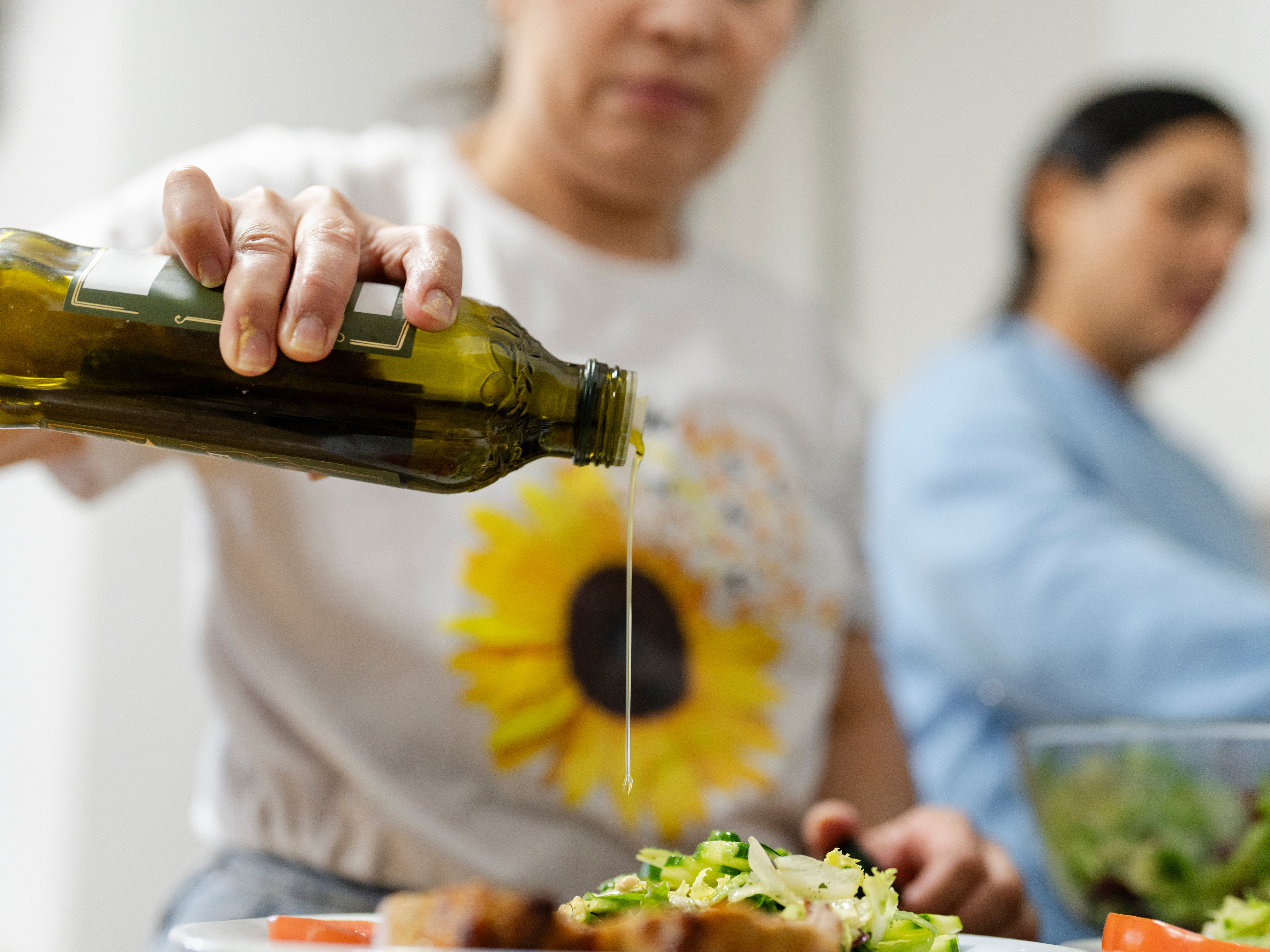 Image of a woman pouring olive oil