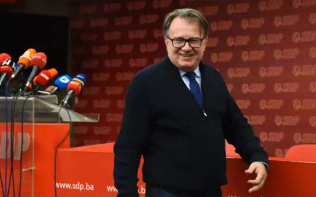 Nikšić za govornicom, mikrofoni, iza njega zid sa znakom SDP-a.