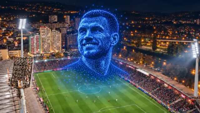 Noćni stadion i lice složeno od svjetala iznad terena.