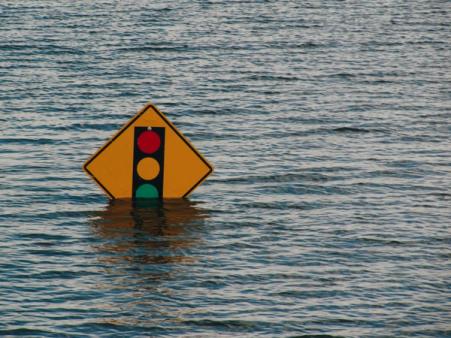 Street sign with flood waters rising above it