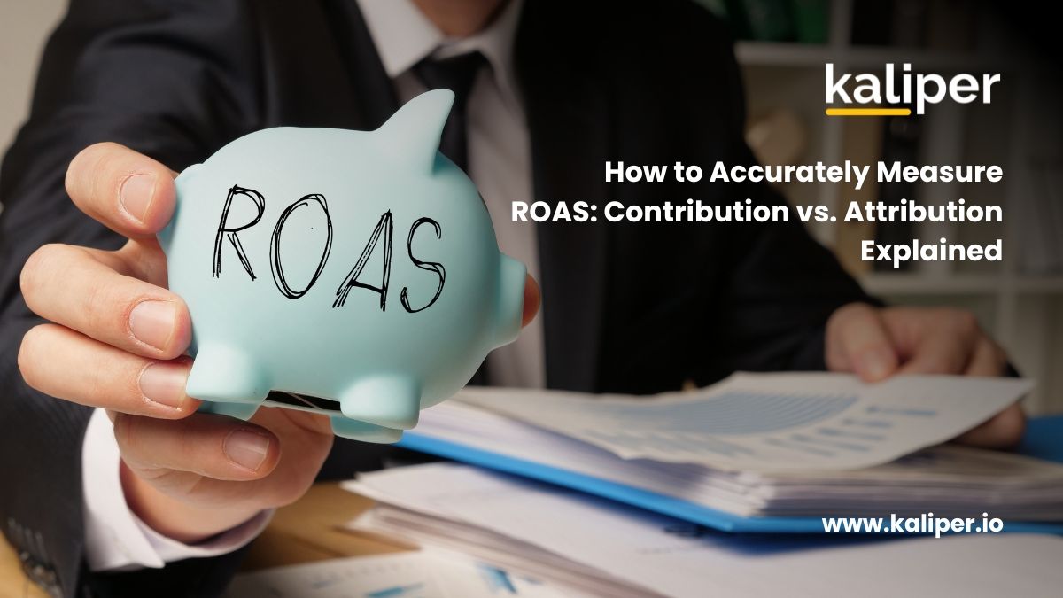 Blog header graphic titled "How to Accurately Measure ROAS: Contribution vs. Attribution Explained," showing a hand holding a light blue piggy bank labeled "ROAS" in front of a stack of papers.