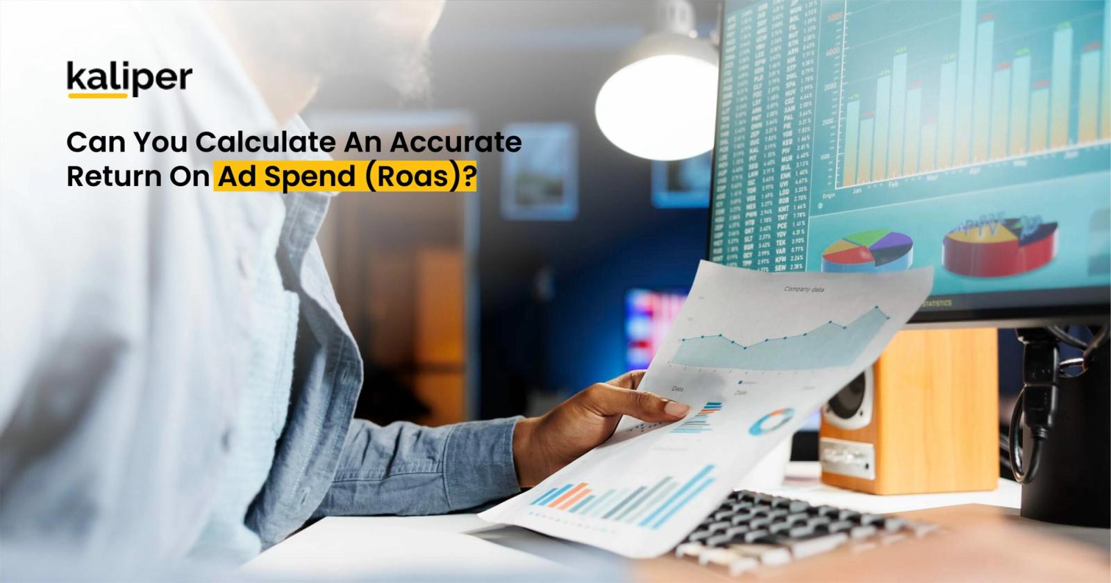 Blog header graphic titled "Can You Calculate An Accurate Return On Ad Spend (Roas)?," showing a person holding a printed chart in front of a monitor displaying stock-style data tables and pie charts.