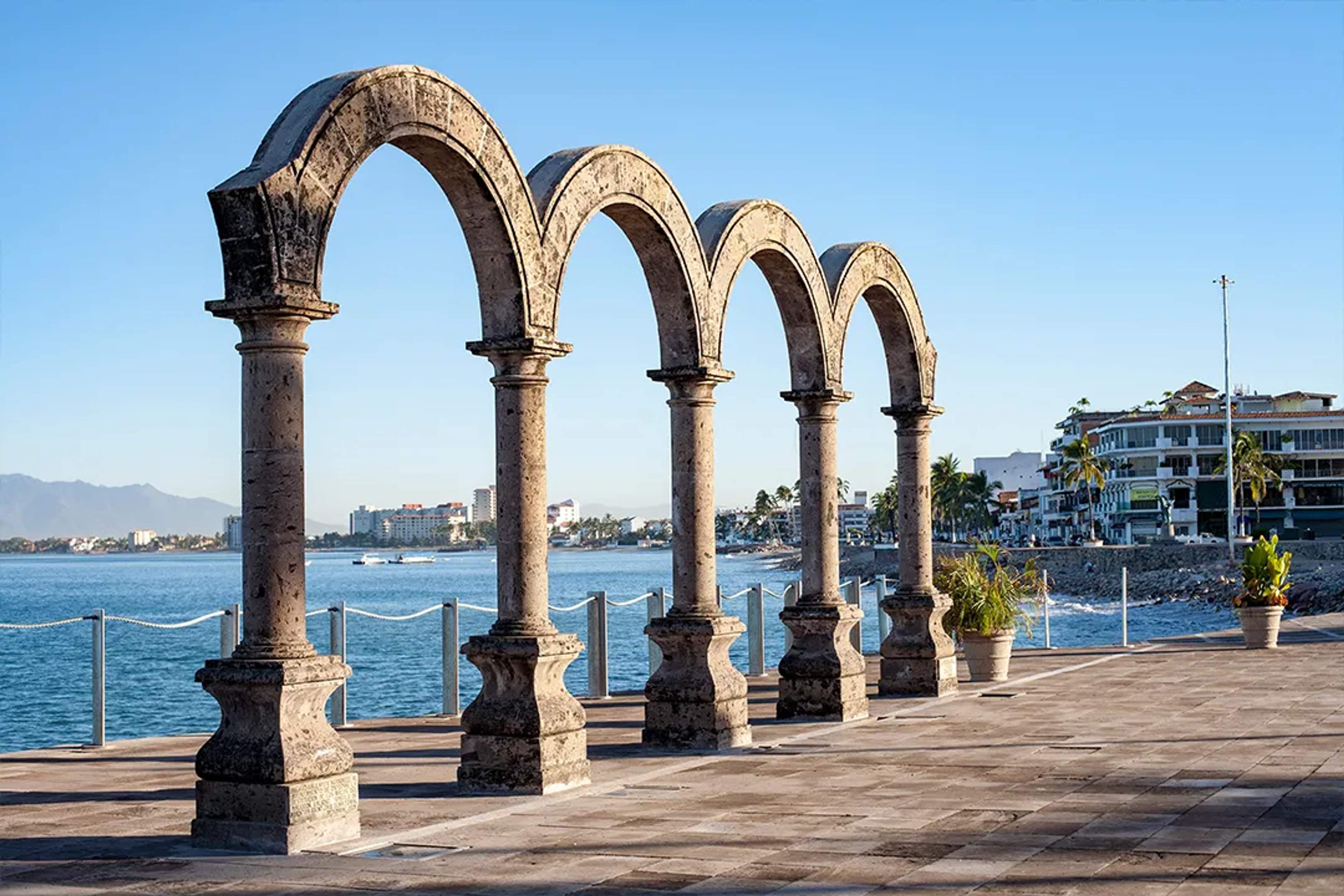 Los Arcos sculpture on Puerto Vallarta Malecon with ocean views, stone arches and coastal skyline