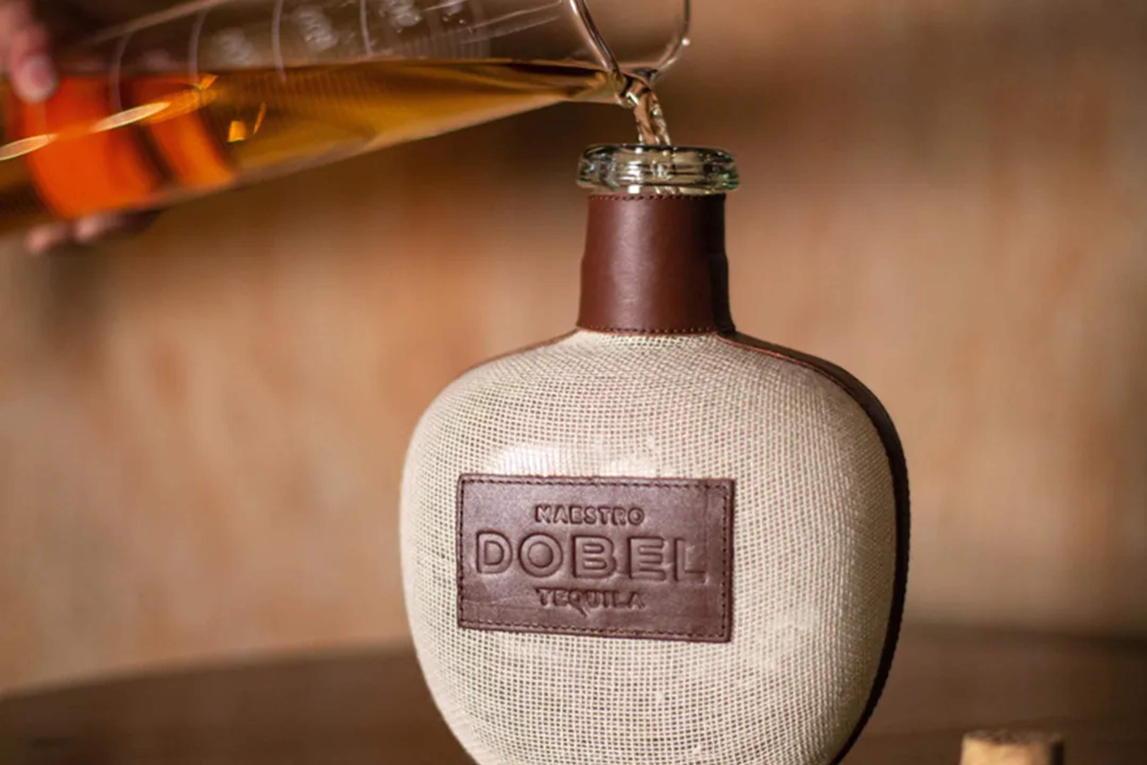 Premium Maestro Dobel Tequila being poured into an artisanal bottle at a distillery in Mexico.