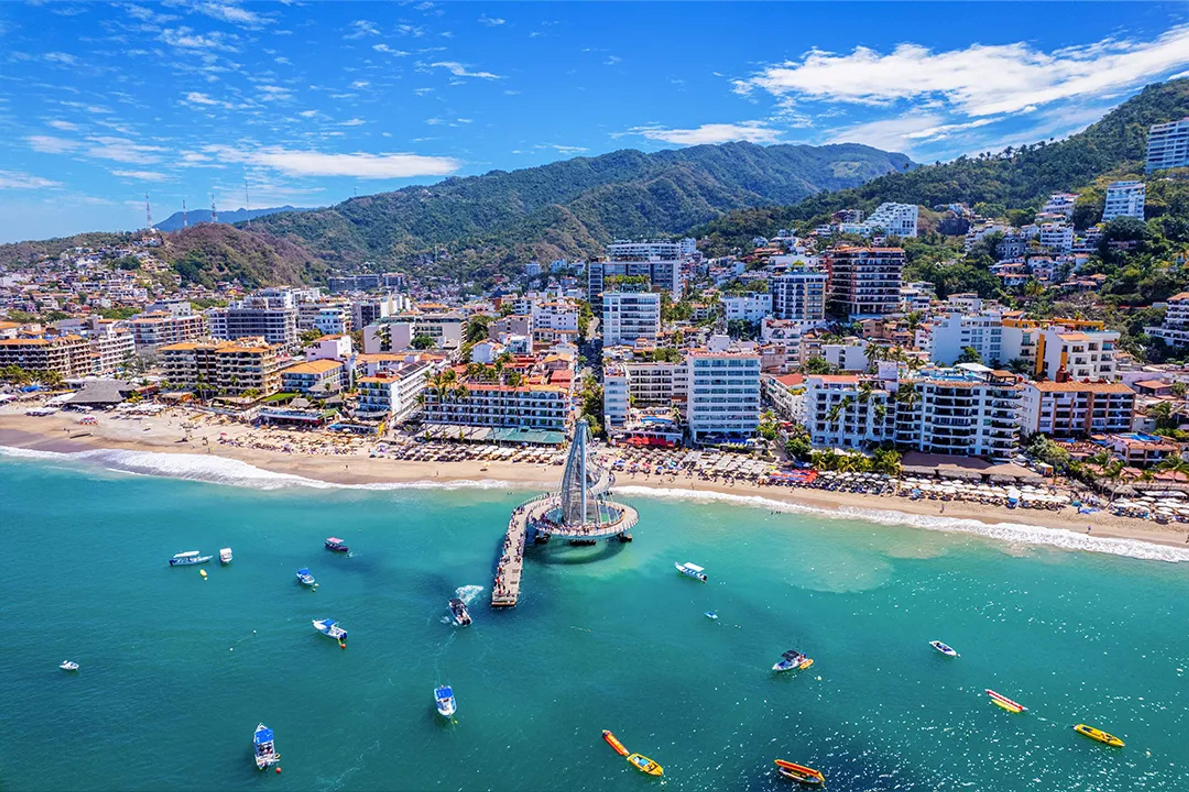 Aerial view of Los Muertos Beach and pier in Puerto Vallarta with boats and Sierra Madre backdrop