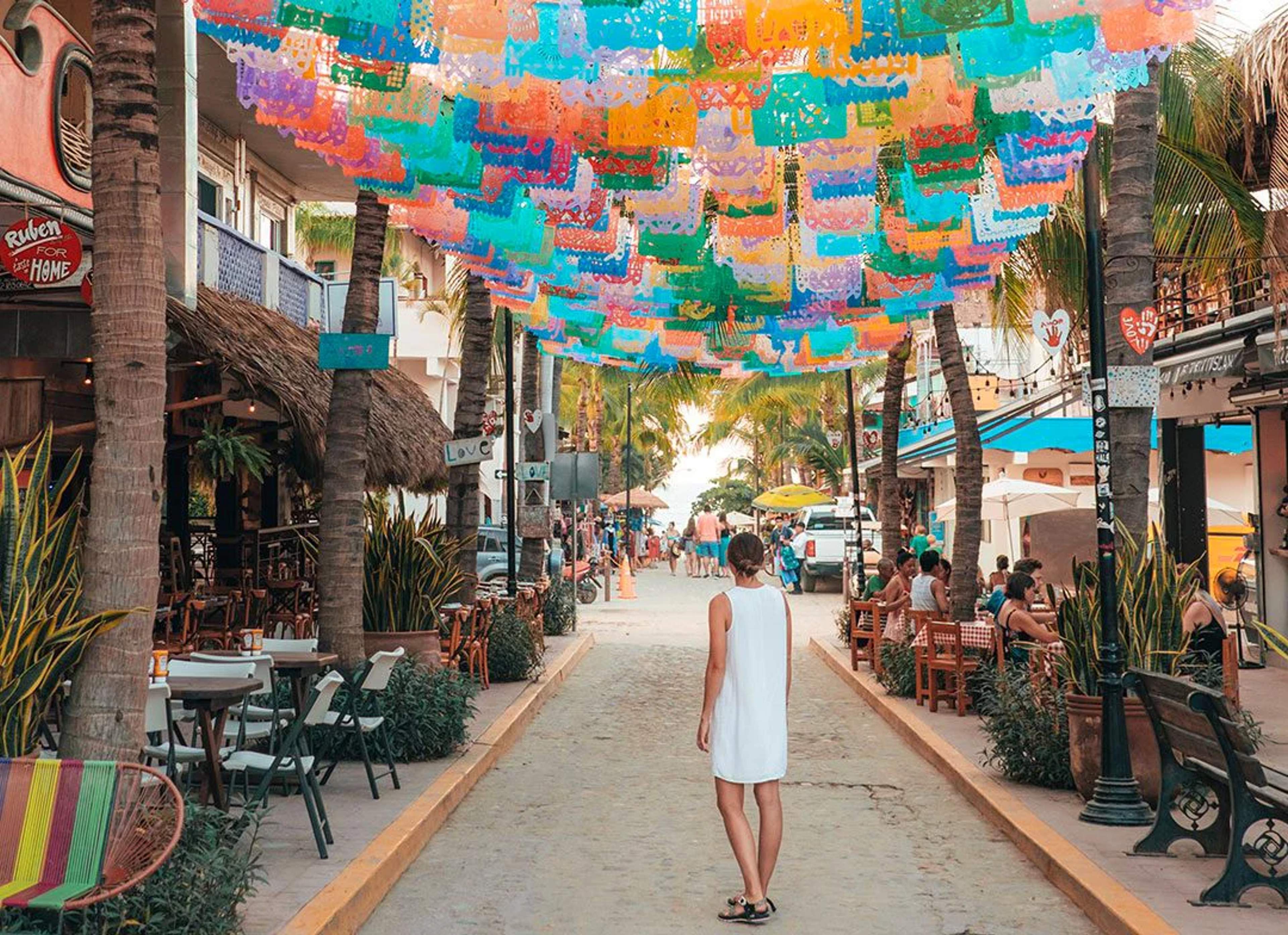 Vibrant street in Sayulita, Mexico, decorated with colorful banners, perfect for a lively and cultural beach town experience.