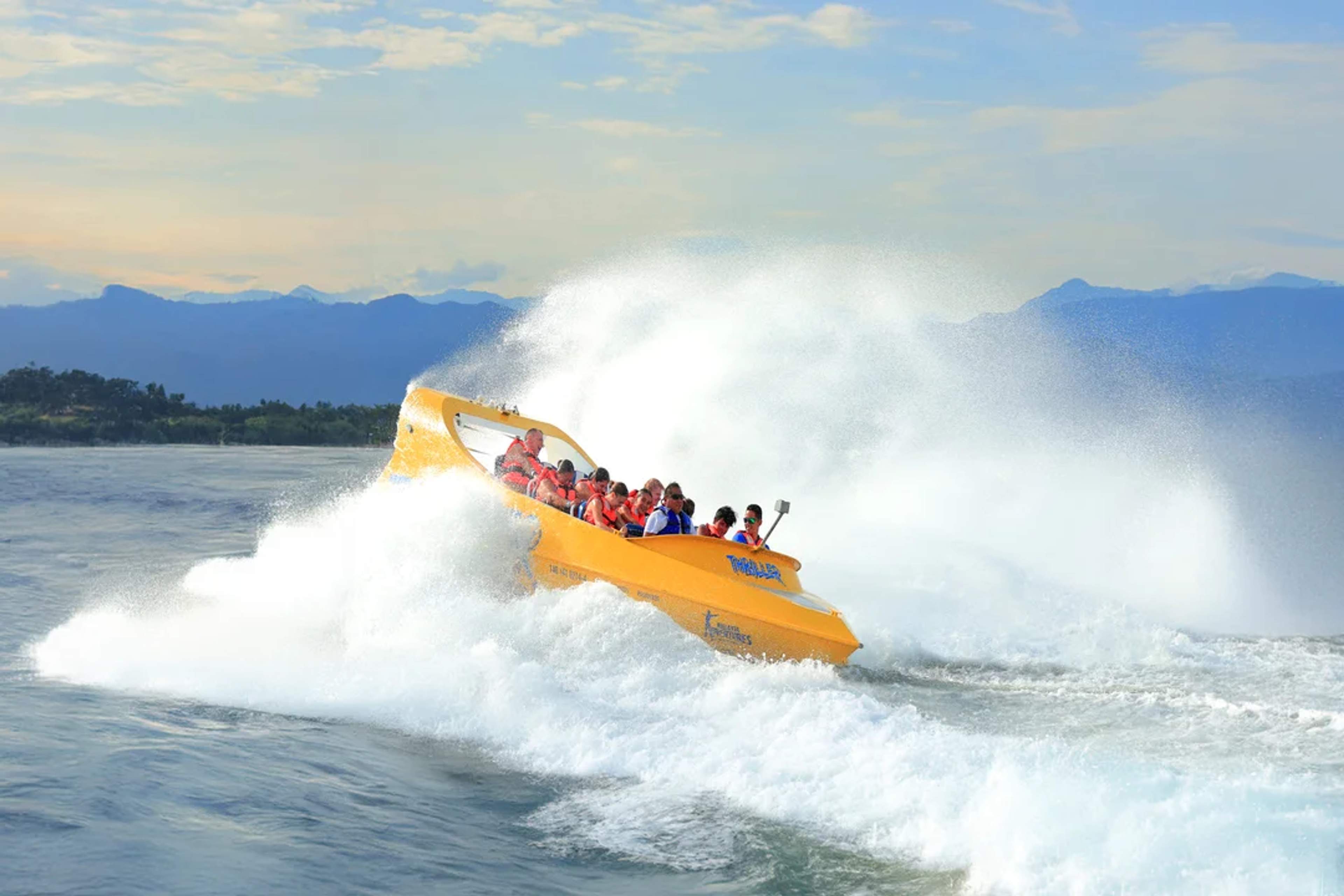 Lancha amarilla salpica mientras los pasajeros disfrutan un emocionante paseo por el mar.