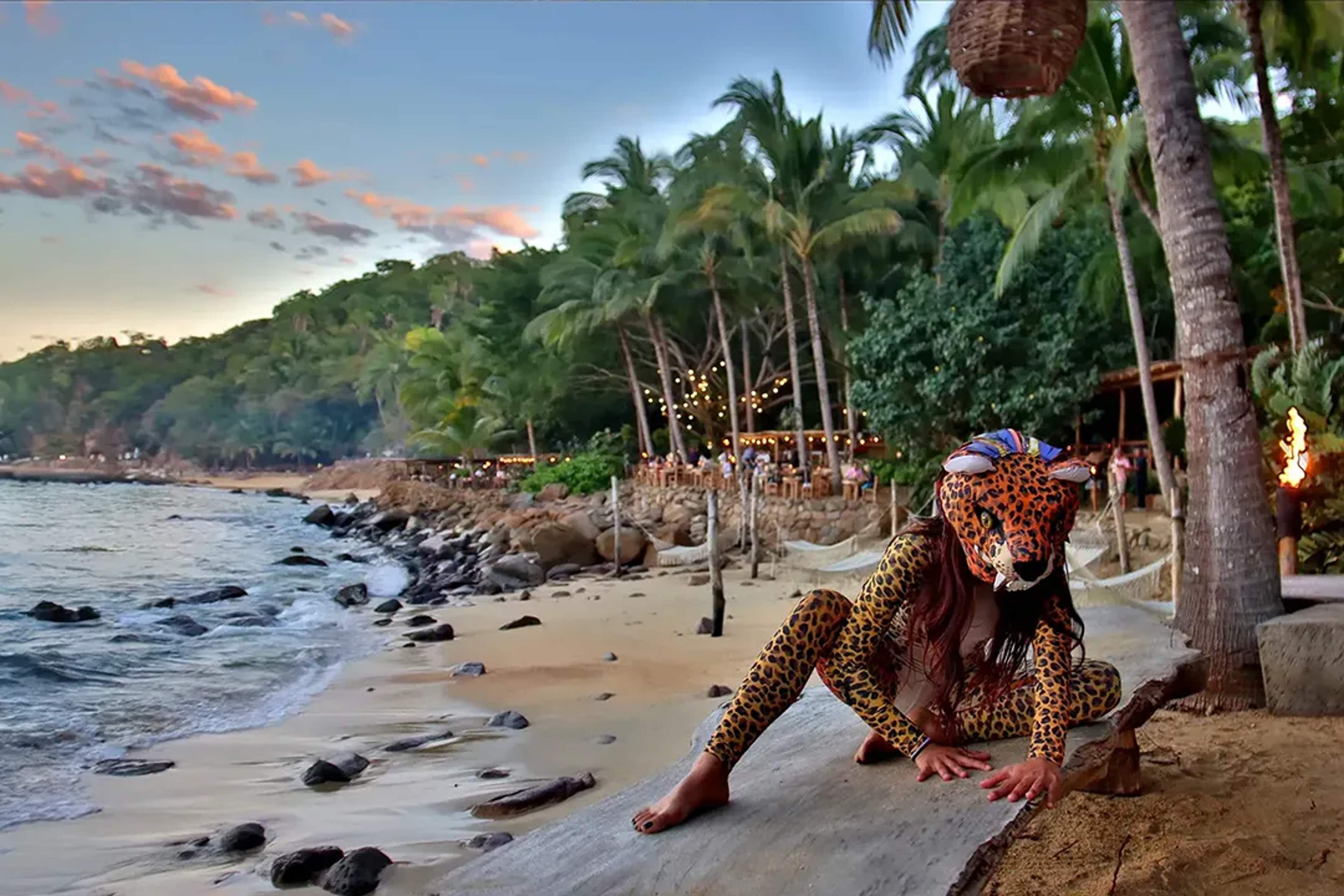 Intérprete ritual en ALMA, Ritmos de la Noche, recorriendo la playa iluminada entre selva y mar