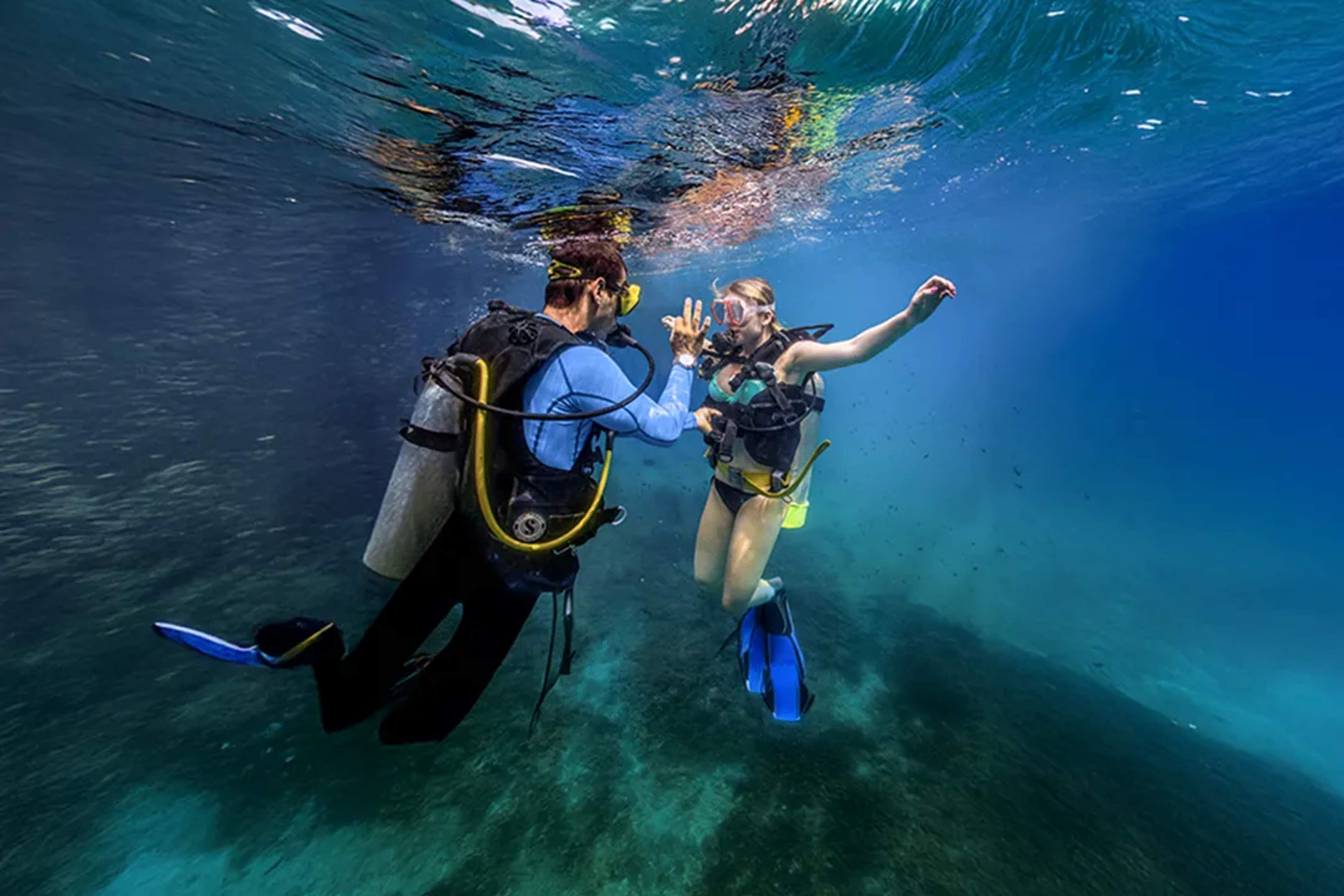 Scuba diving lesson in Puerto Vallarta with instructor guiding beginner diver in clear blue waters