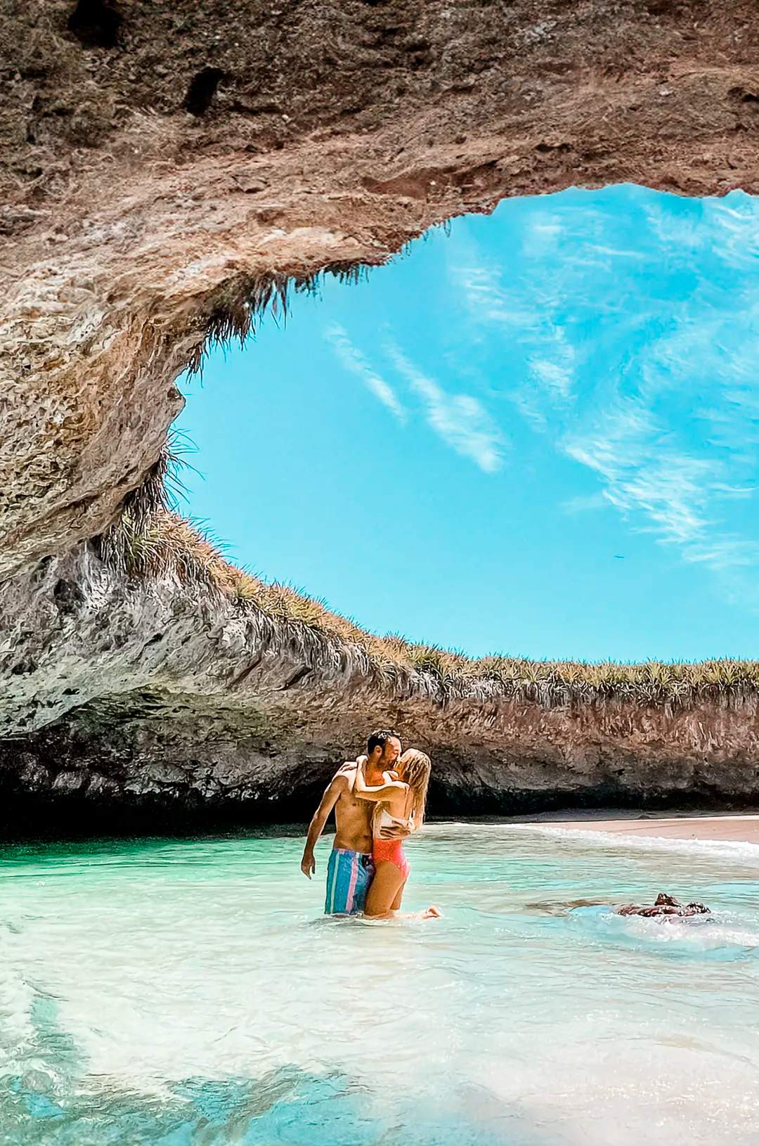 A couple embraces in the clear waters of Hidden Beach, Marietas Islands.