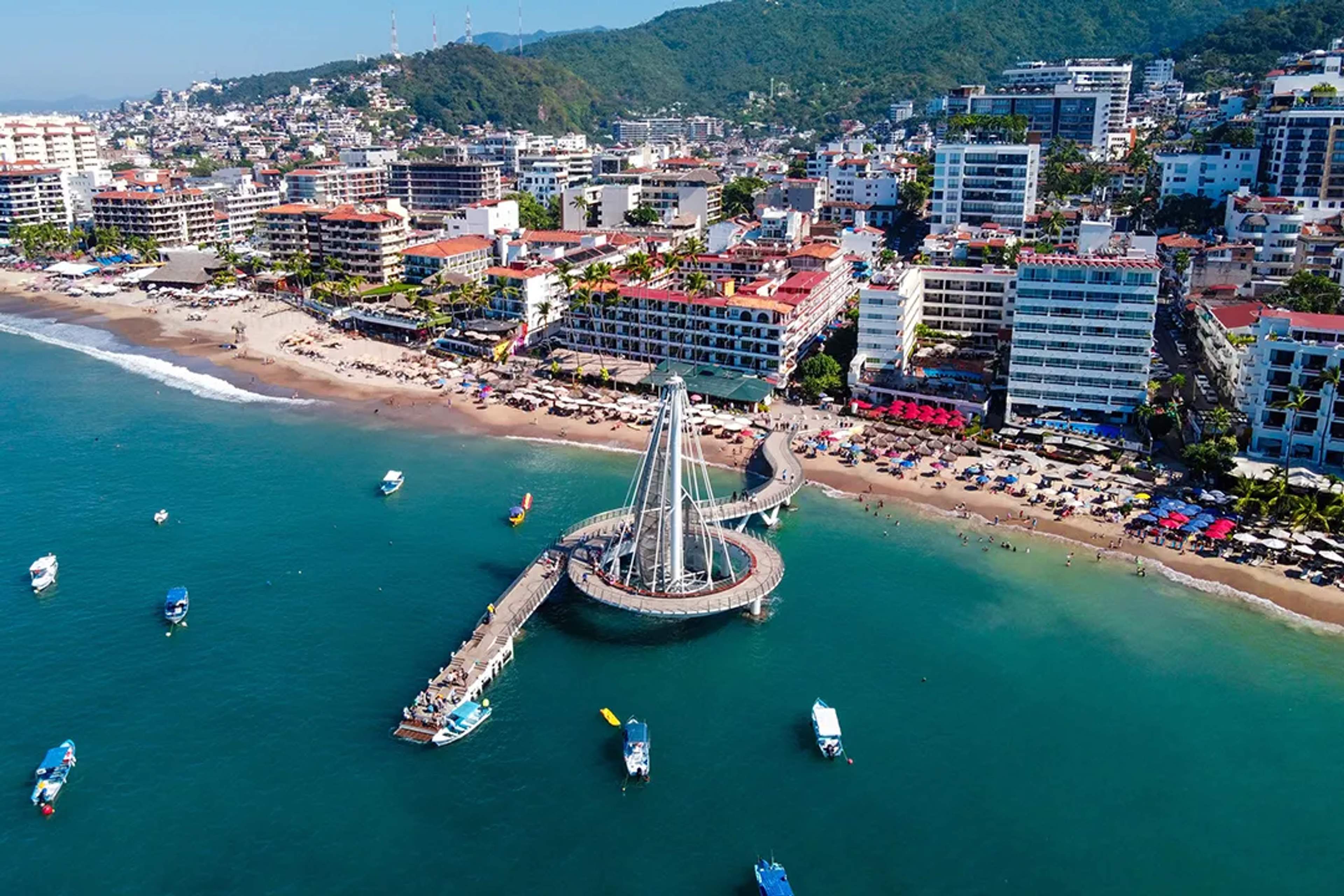 Aerial view of Los Muertos Pier in Puerto Vallarta surrounded by beaches, boats, and hotels.