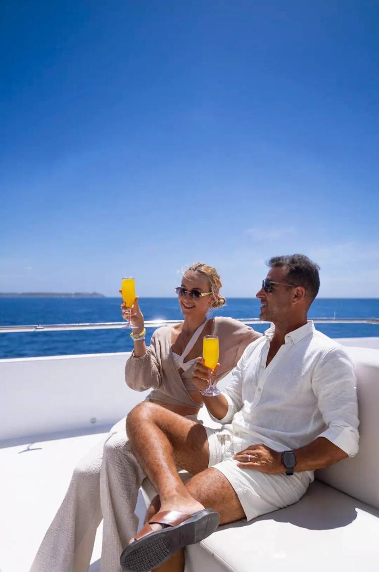 Couple enjoying premium cocktails aboard the Seventeen Catamaran while sailing the waters of Los Cabos.