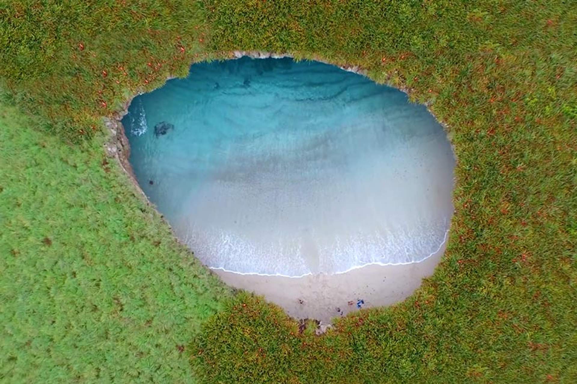 Aerial view of the secluded Hidden Beach with turquoise waters, surrounded by lush greenery on Marieta Islands, Mexico.