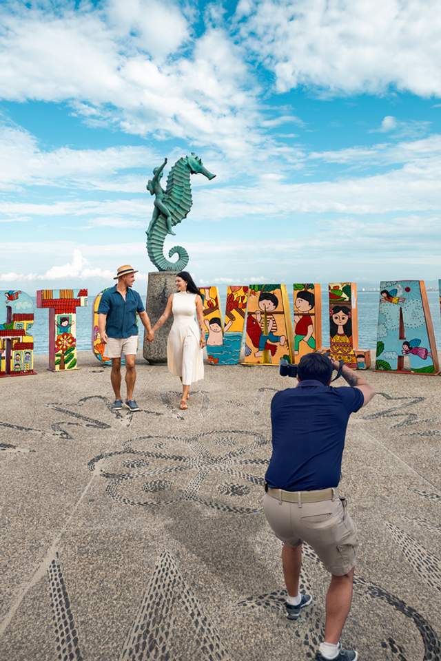 Couple on Puerto Vallarta sign with a professional photographer during a Puerto Vallarta City Tour.