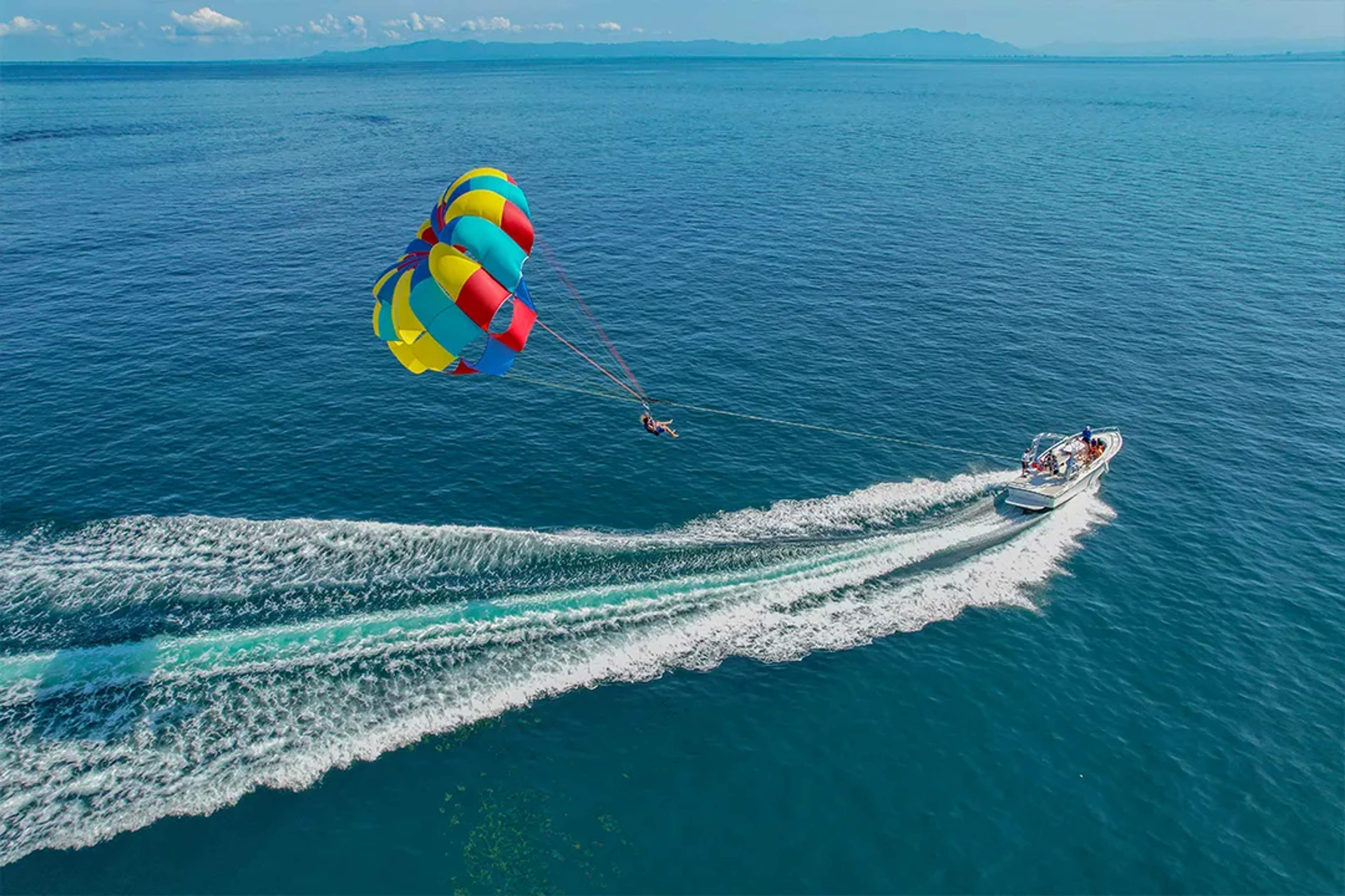 Parasailing adventure in Puerto Vallarta, soaring above the ocean with panoramic views and colorful parachute