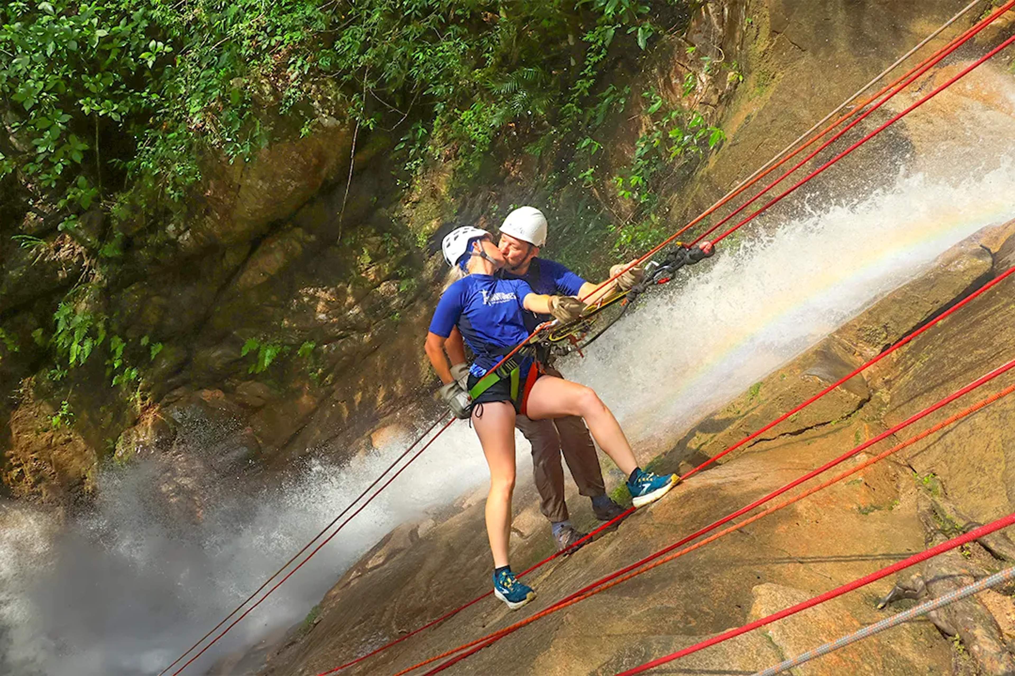 Couple rappelling down a jungle waterfall during Outdoor Adventure in Puerto Vallarta, sharing adrenaline and fun