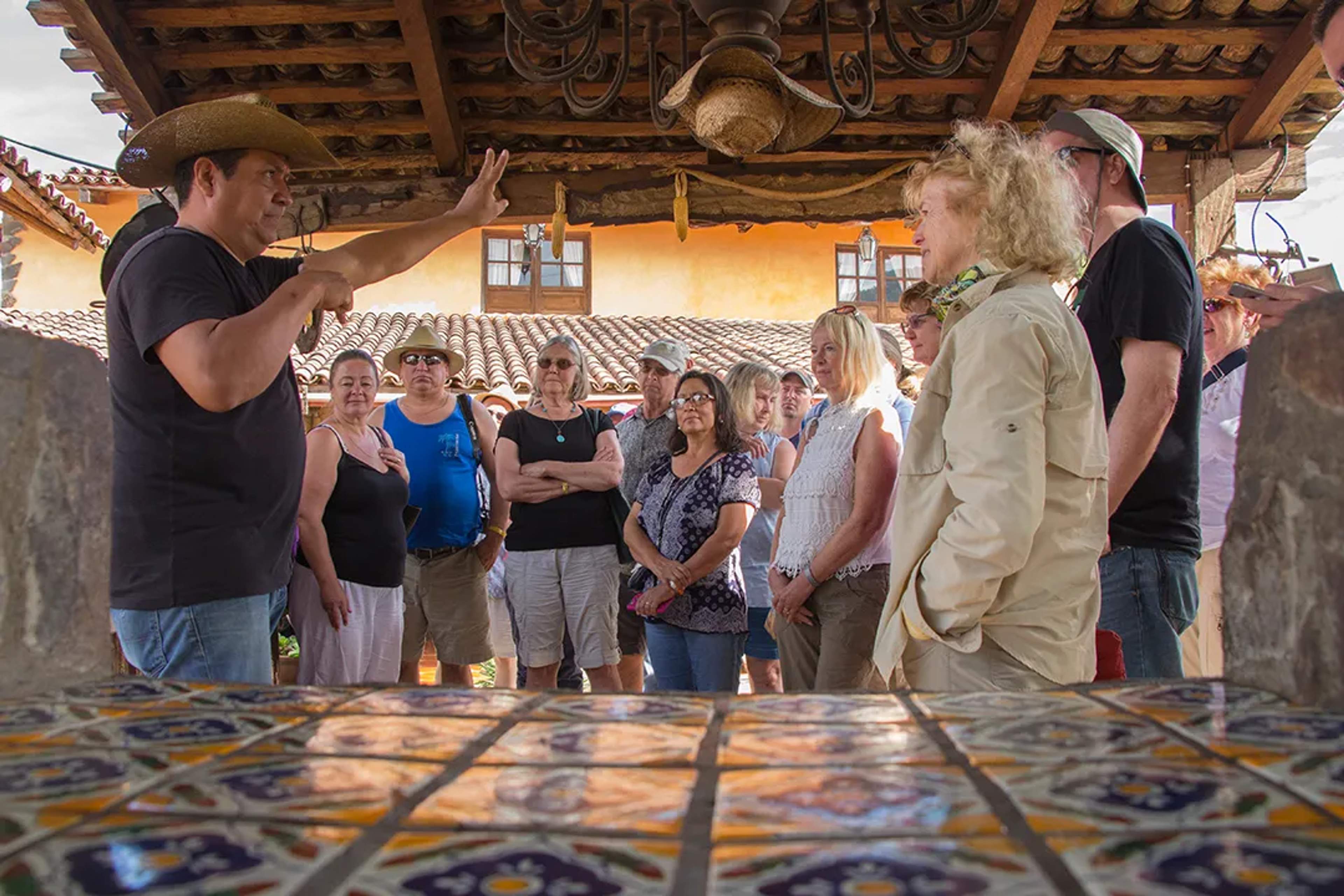 Local guide sharing history and culture with visitors during a guided tour in San Sebastián del Oeste, Mexico