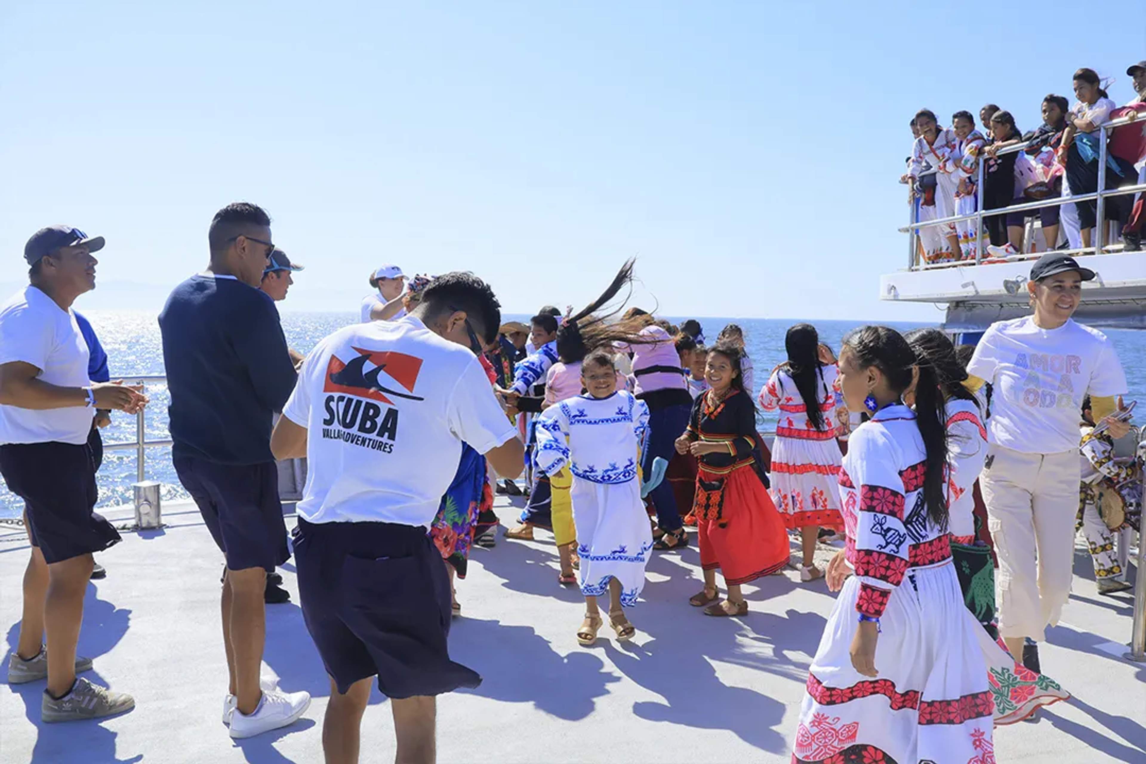 Niños bailando en un circulo en un catamaran