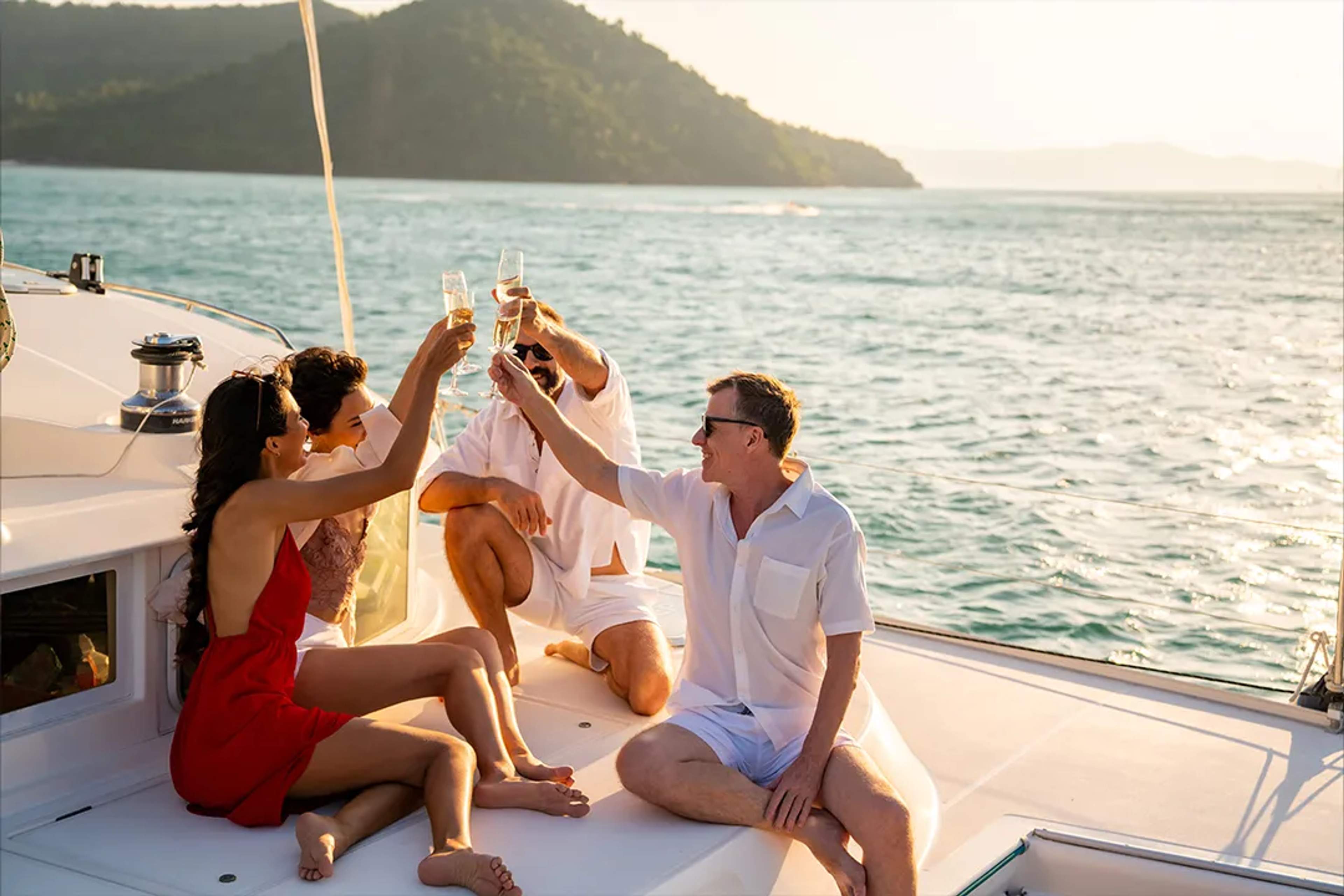 Friends toasting with champagne on a yacht under the sun, enjoying the ocean breeze.