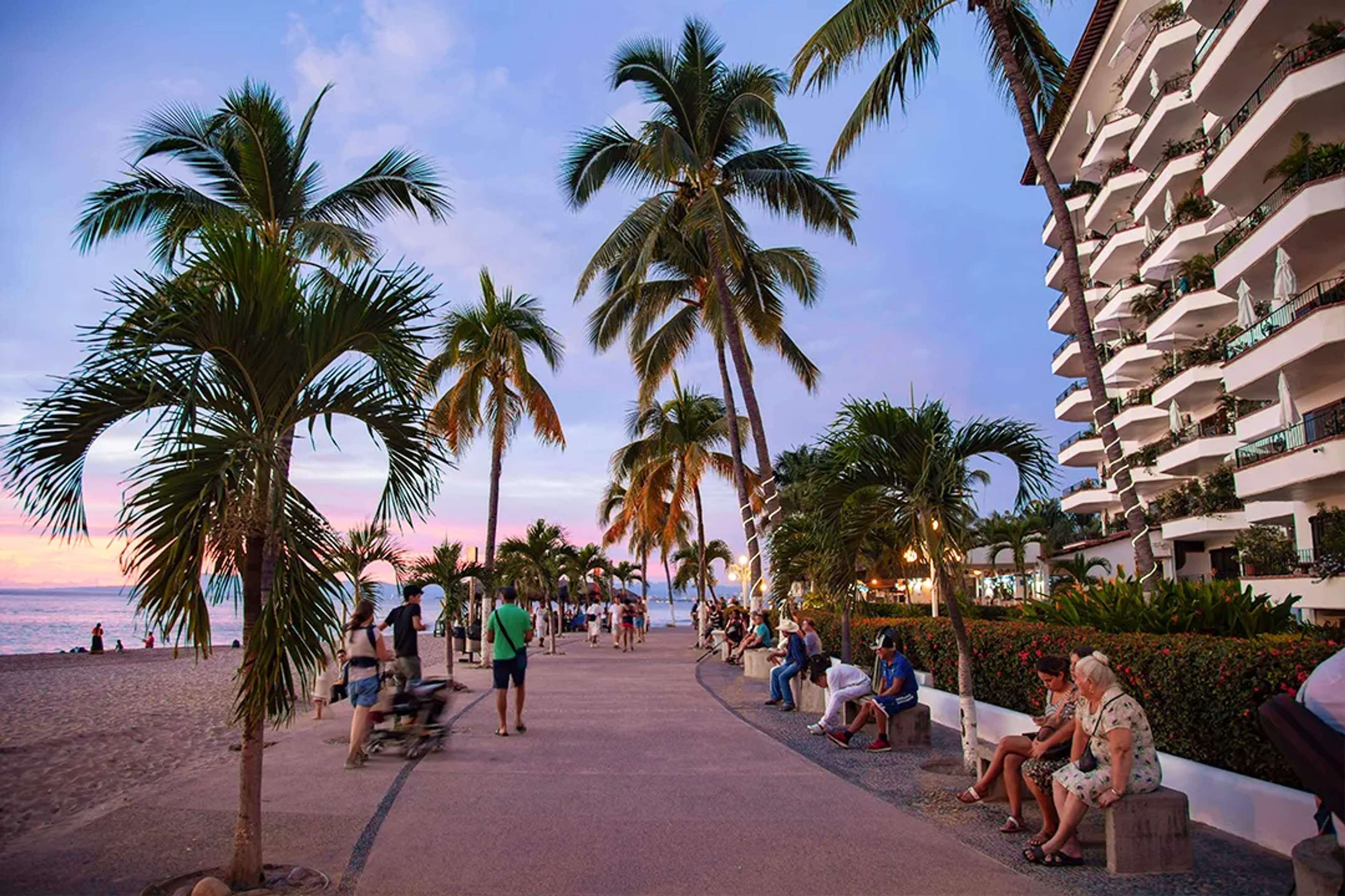 Sunset stroll along the Puerto Vallarta Malecón with palm trees and oceanfront views