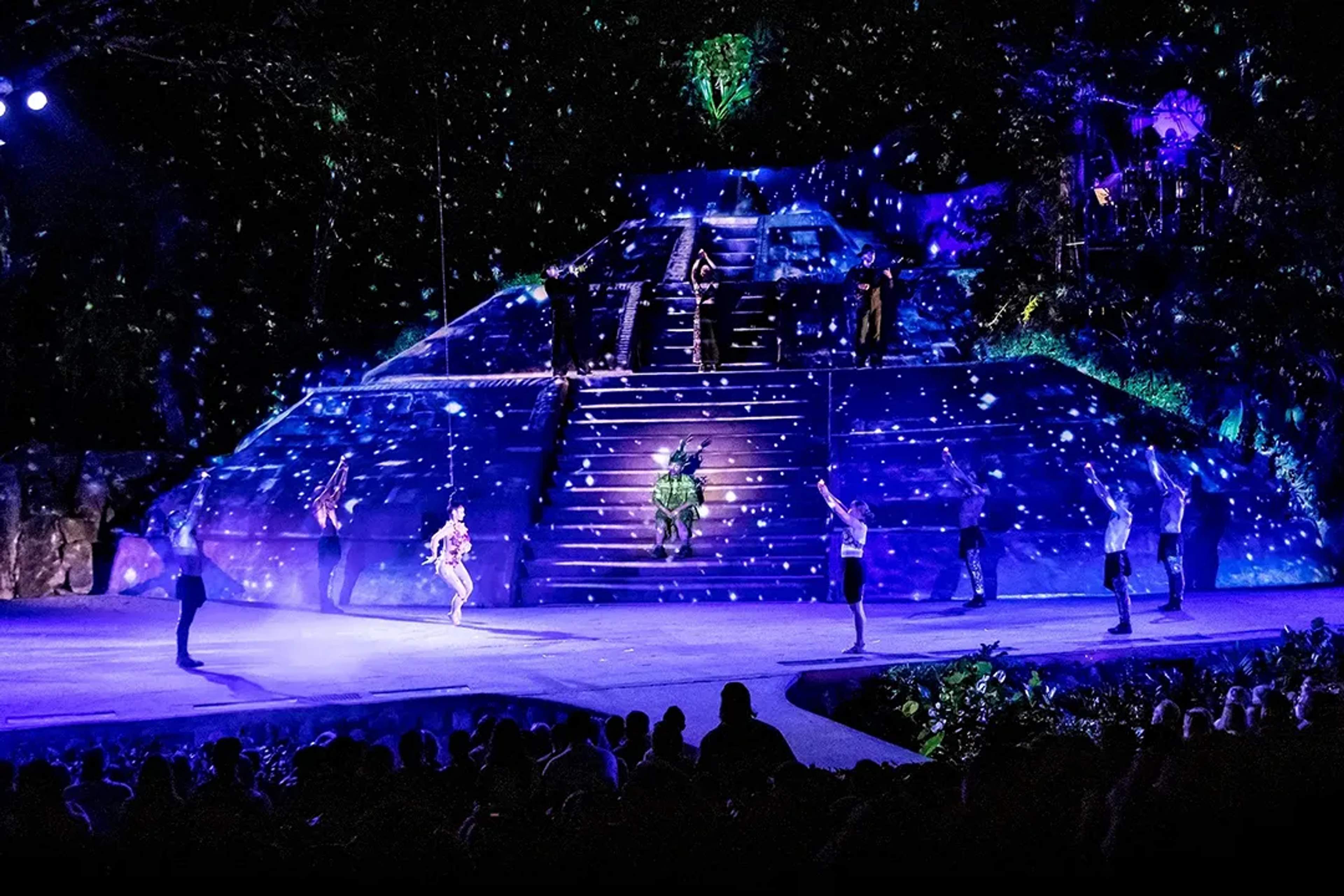 Show de ALMA, Ritmos de la Noche con pirámide selvática iluminada y bailarines en escena en Vallarta