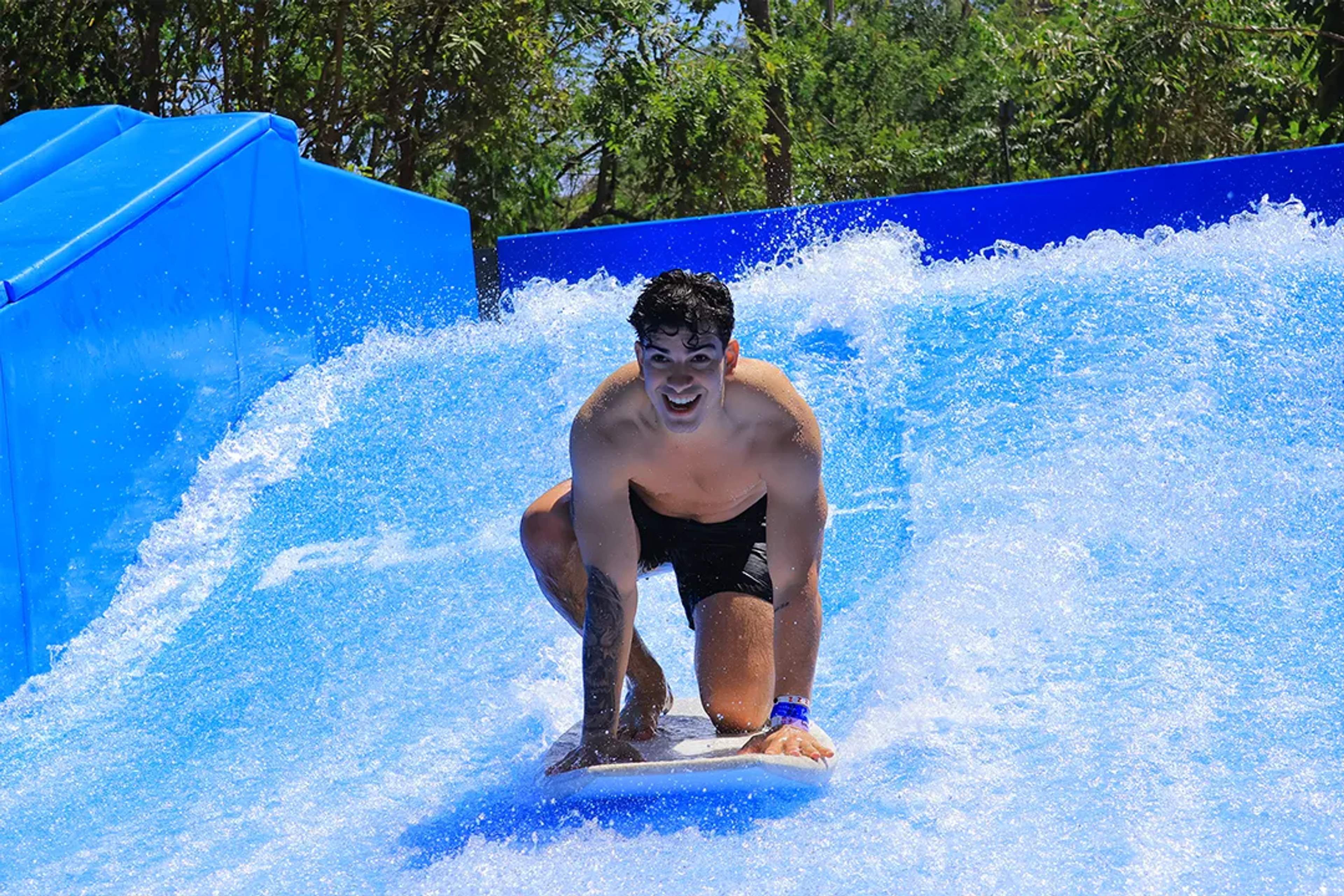 Man bodyboarding on a FlowRider wave simulator during the Ocean Mania adventure tour in Puerto Vallarta