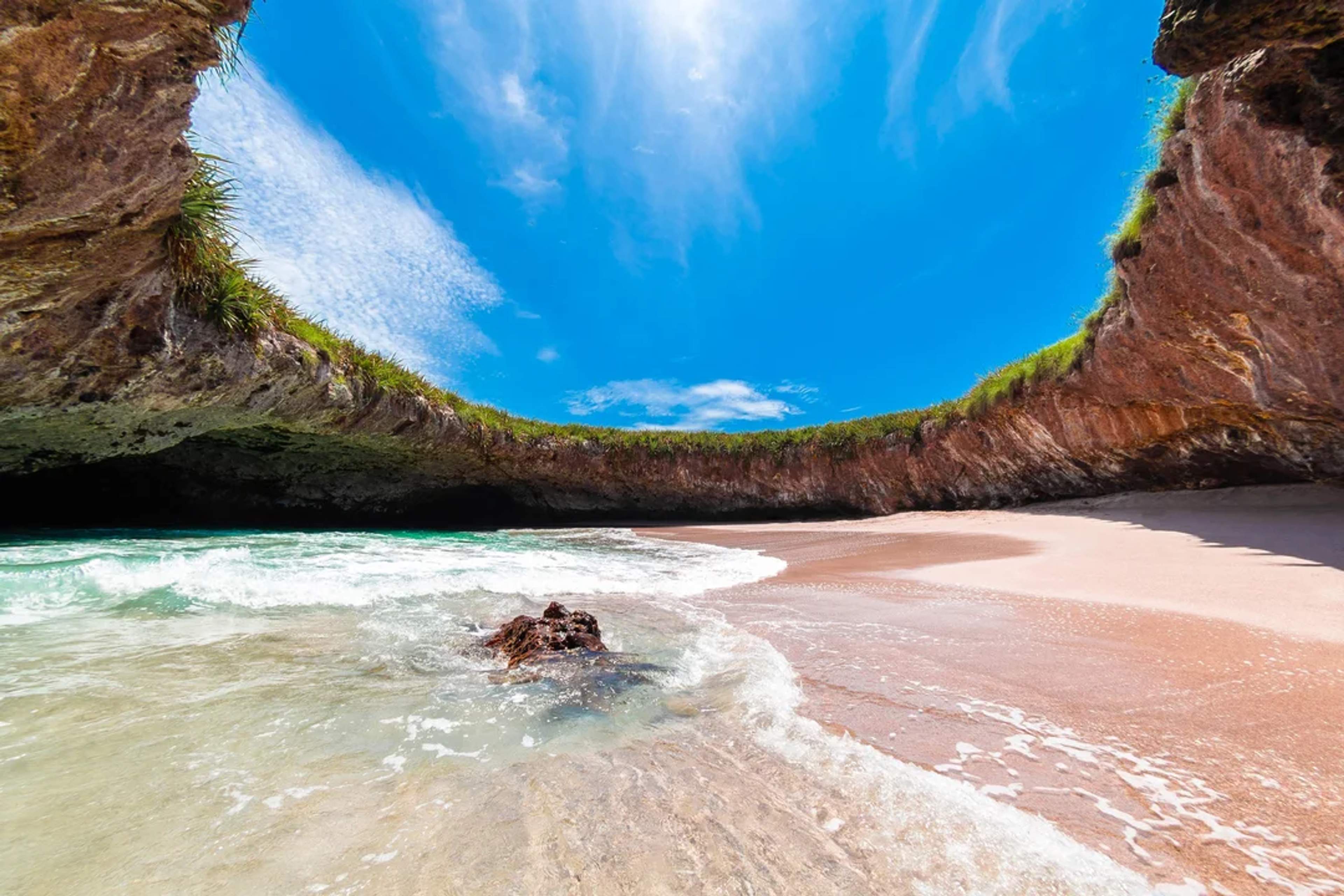La Playa Escondida en Islas Marietas muestra una hermosa cala bajo una cúpula rocosa natural.