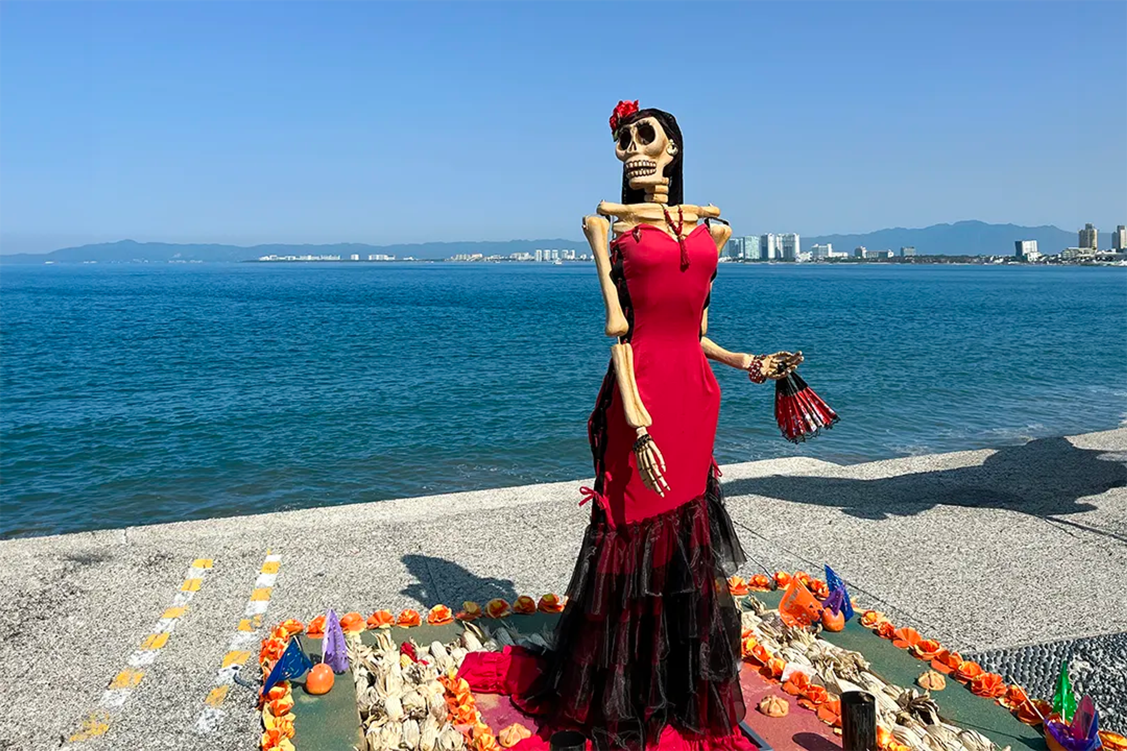 Celebración del Día de Muertos con flores de cempasúchil y velas iluminando la noche.