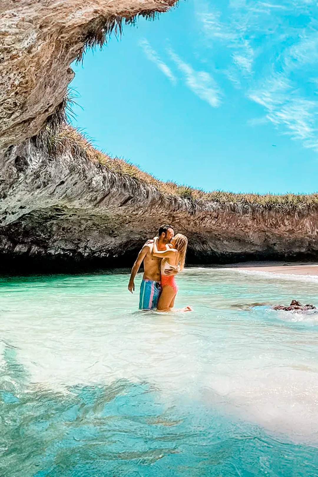 A couple embraces in the clear waters of Hidden Beach, Marietas Islands.