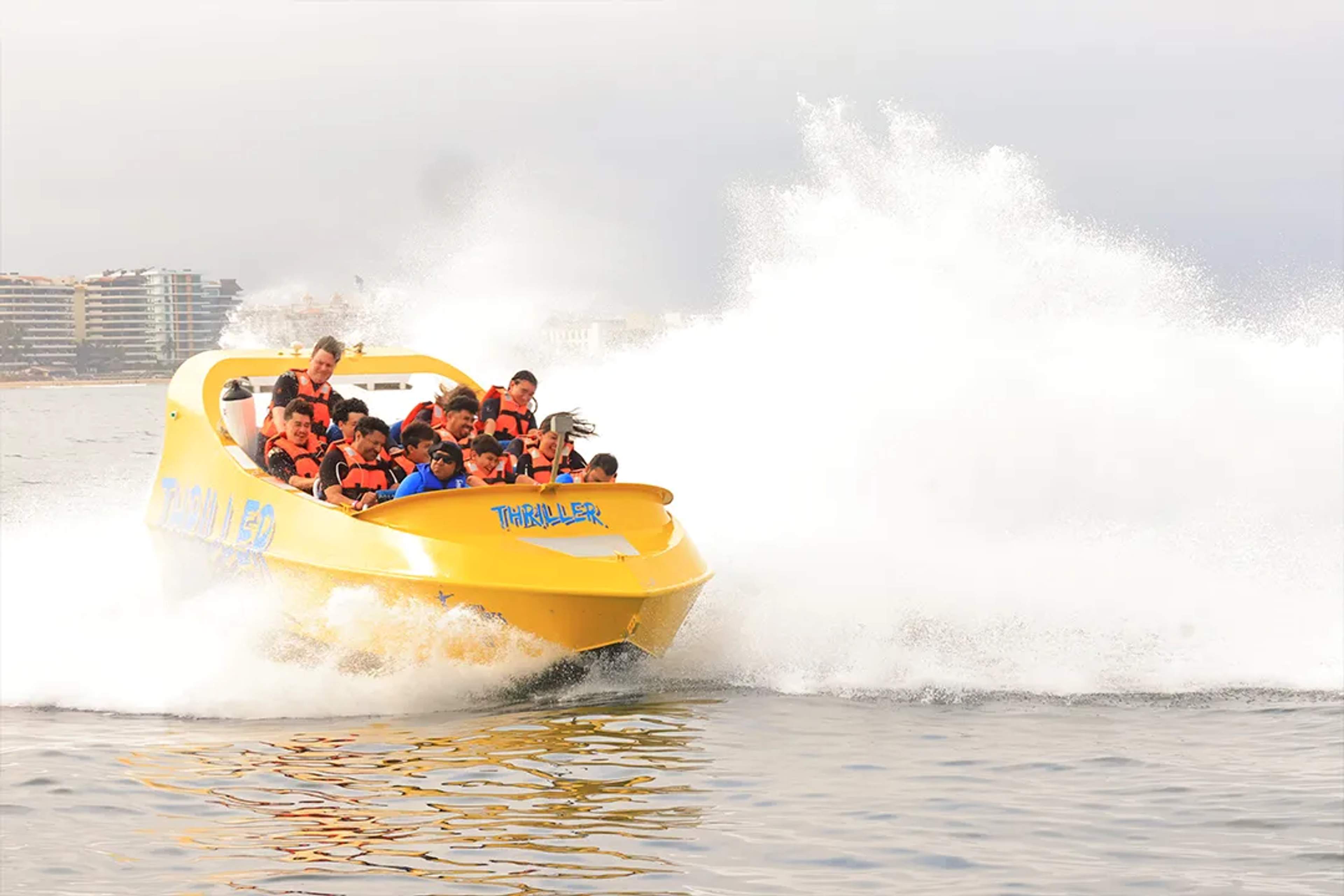 Yellow speedboat splashing water in Puerto Vallarta during an Ocean Mania adventure tour experience