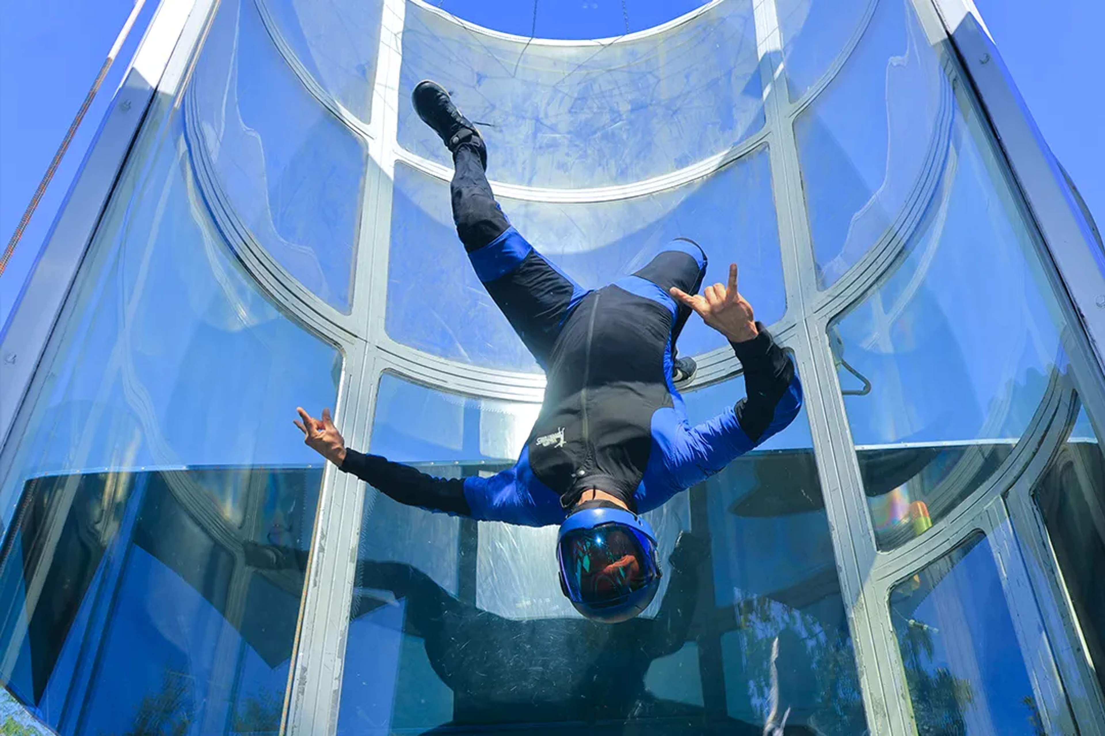 Adventurer enjoys zero gravity inside a powerful wind tunnel, flying freely like a skydiver at Extreme Adventure.