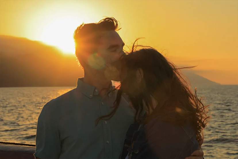 Romantic sunset cruise in Puerto Vallarta with couple embracing over Banderas Bay