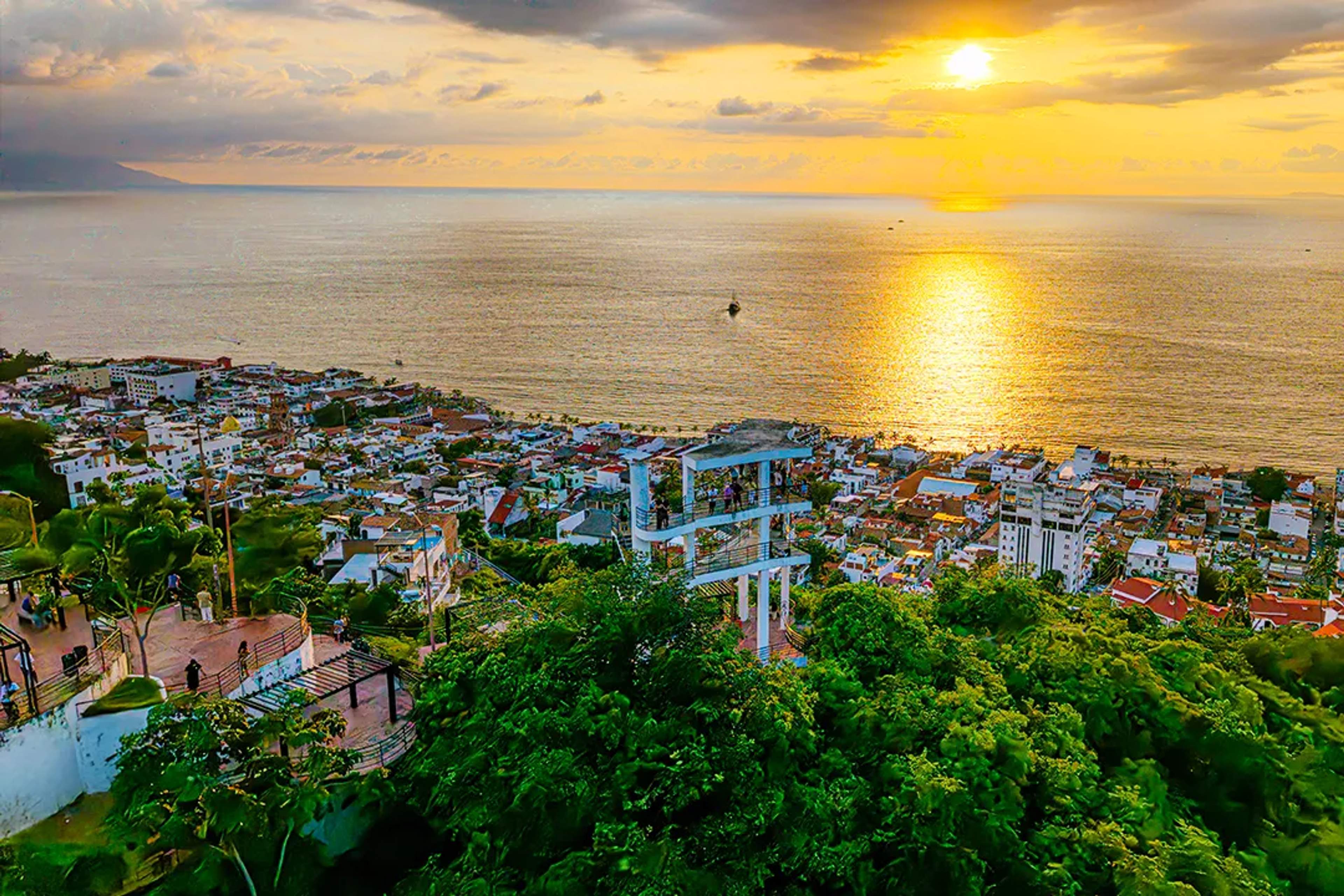 Vista panorámica al atardecer desde El Mirador de la Cruz en Puerto Vallarta con centro y Bahía de Banderas