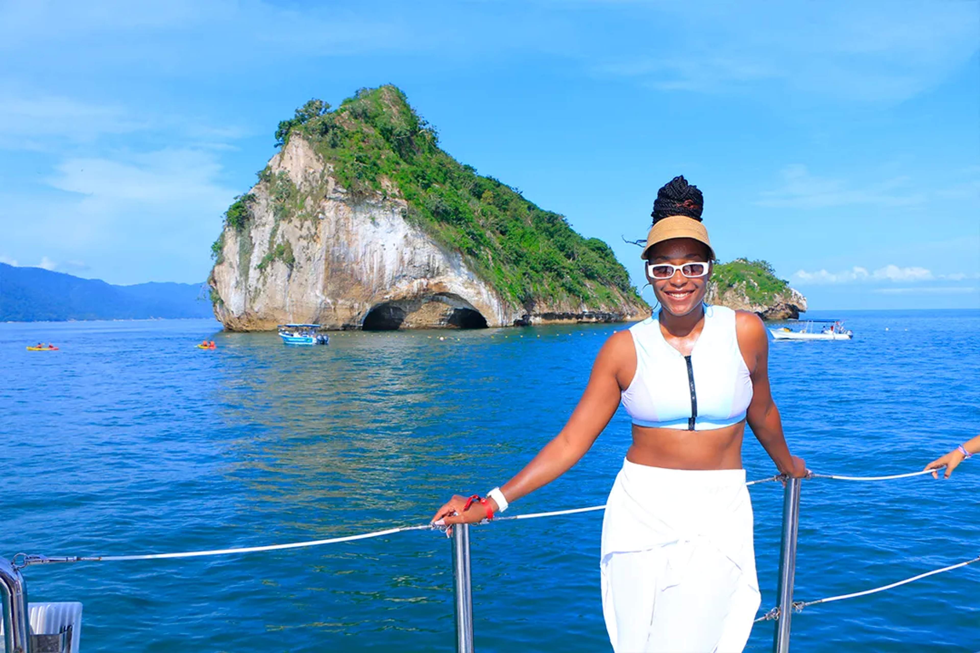 Viajera sonriente en lancha frente a Islas Marietas Puerto Vallarta, aguas cristalinas y formación icónica mar