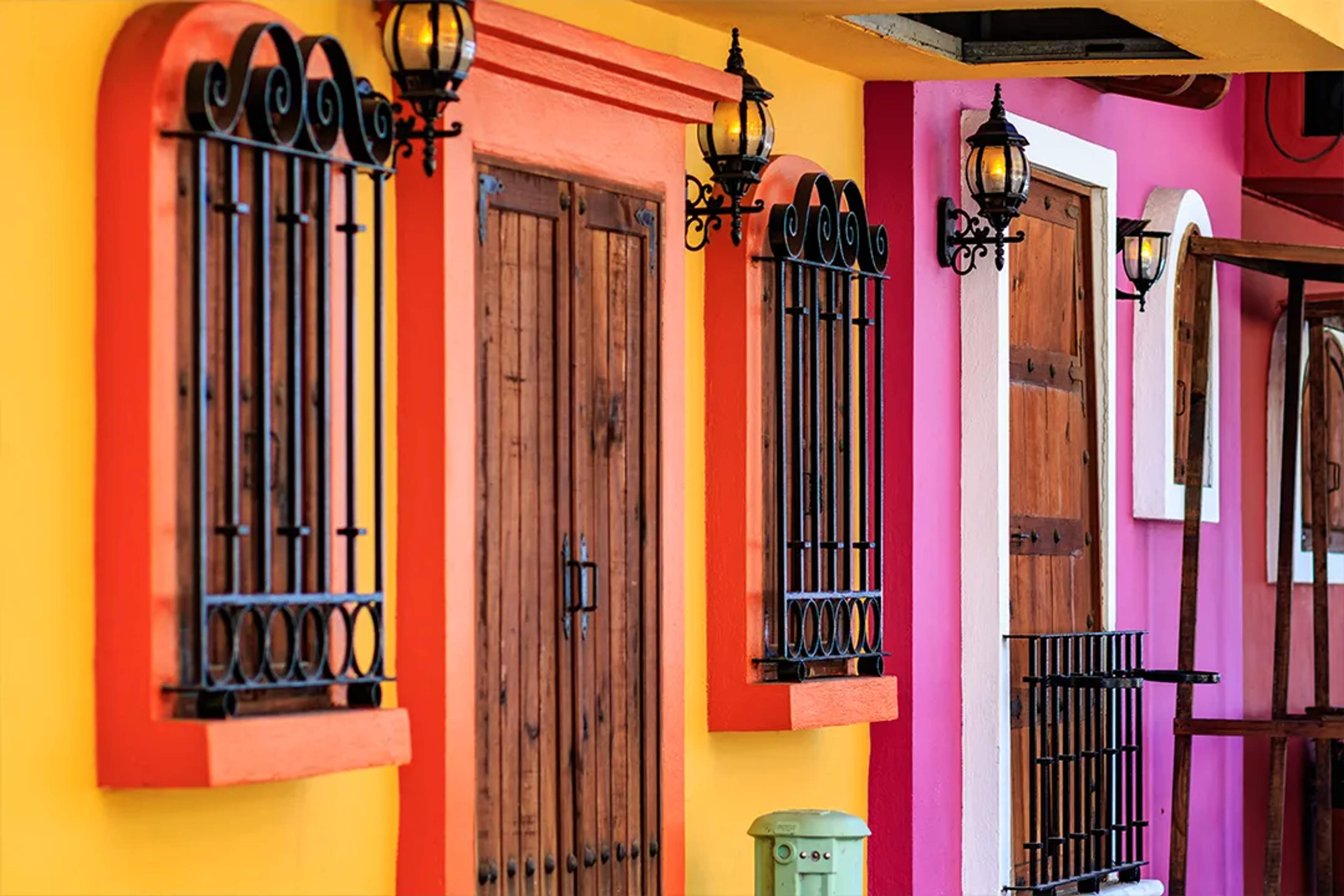Colorful colonial-style house in Puerto Vallarta with bright yellow, pink, and orange walls.