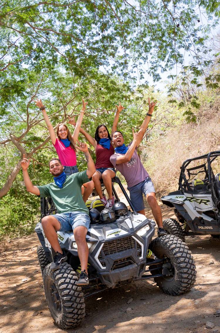 Grupo alegre en un ATV Polaris RZR posando para una foto en medio de la selva tropical cerca de Sayulita.