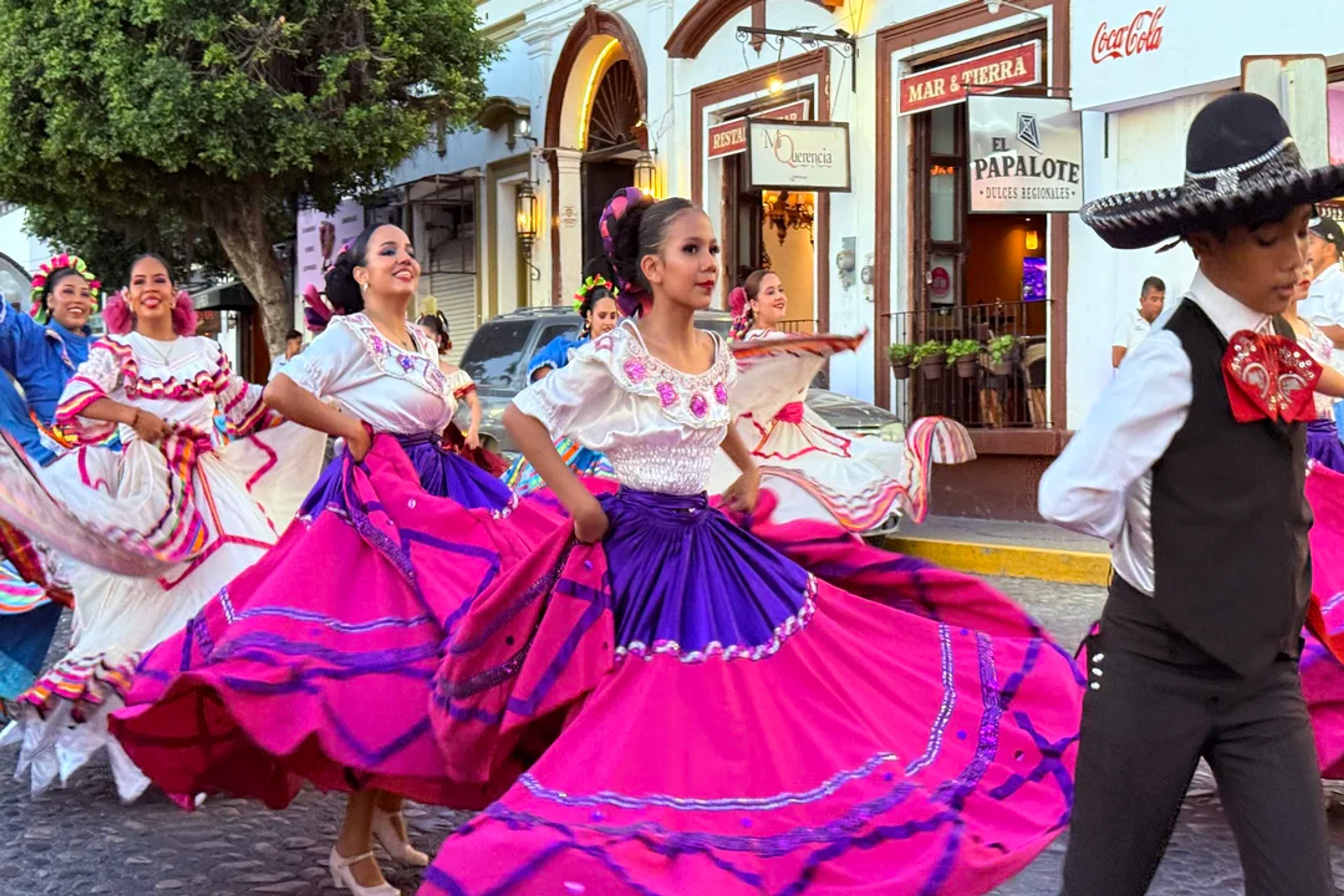 Dancers in vibrant traditional costumes perform folkloric ballet on the streets of Puerto Vallarta.