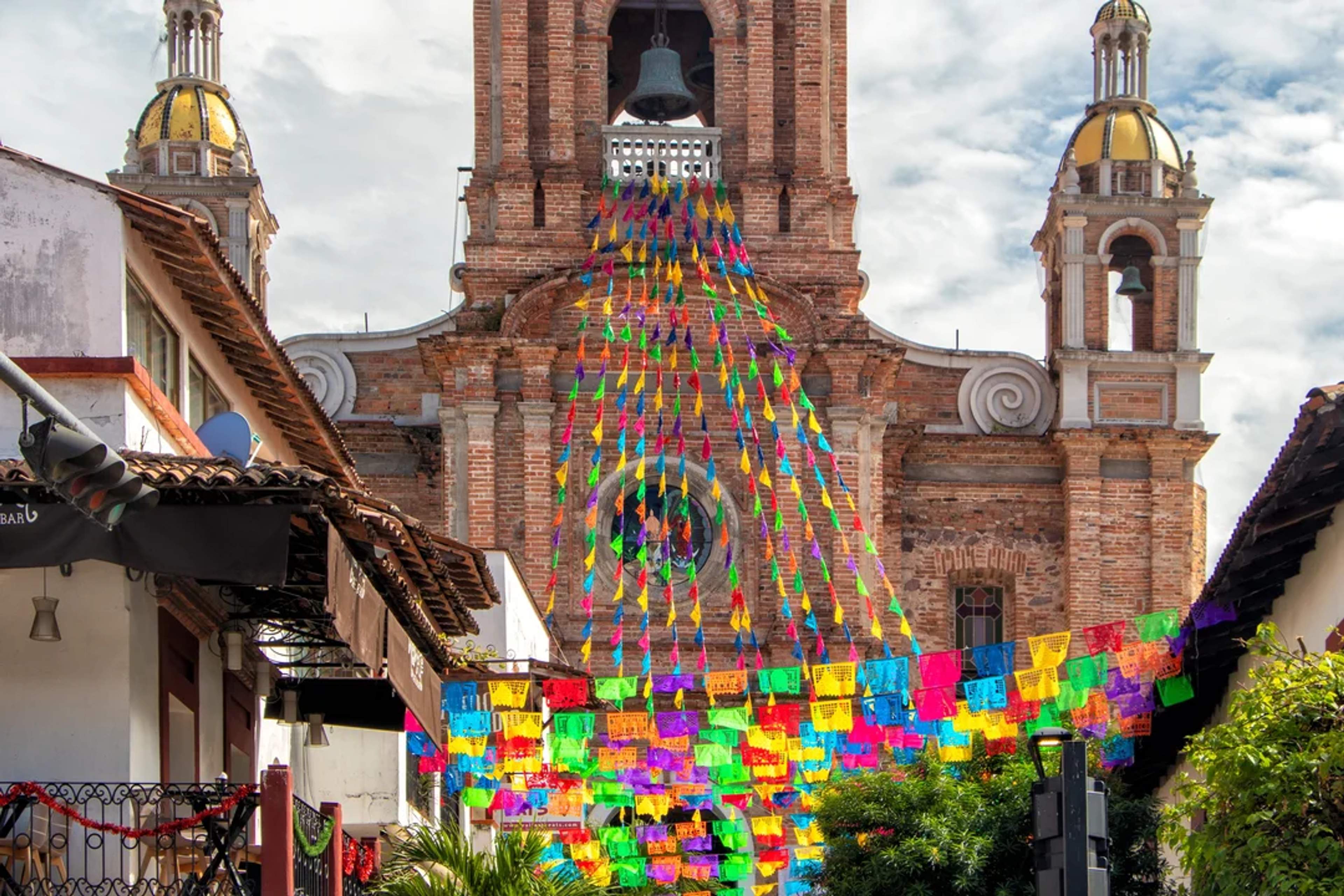 Colorful papel picado decorates the street in front of Our Lady of Guadalupe Church in Vallarta.