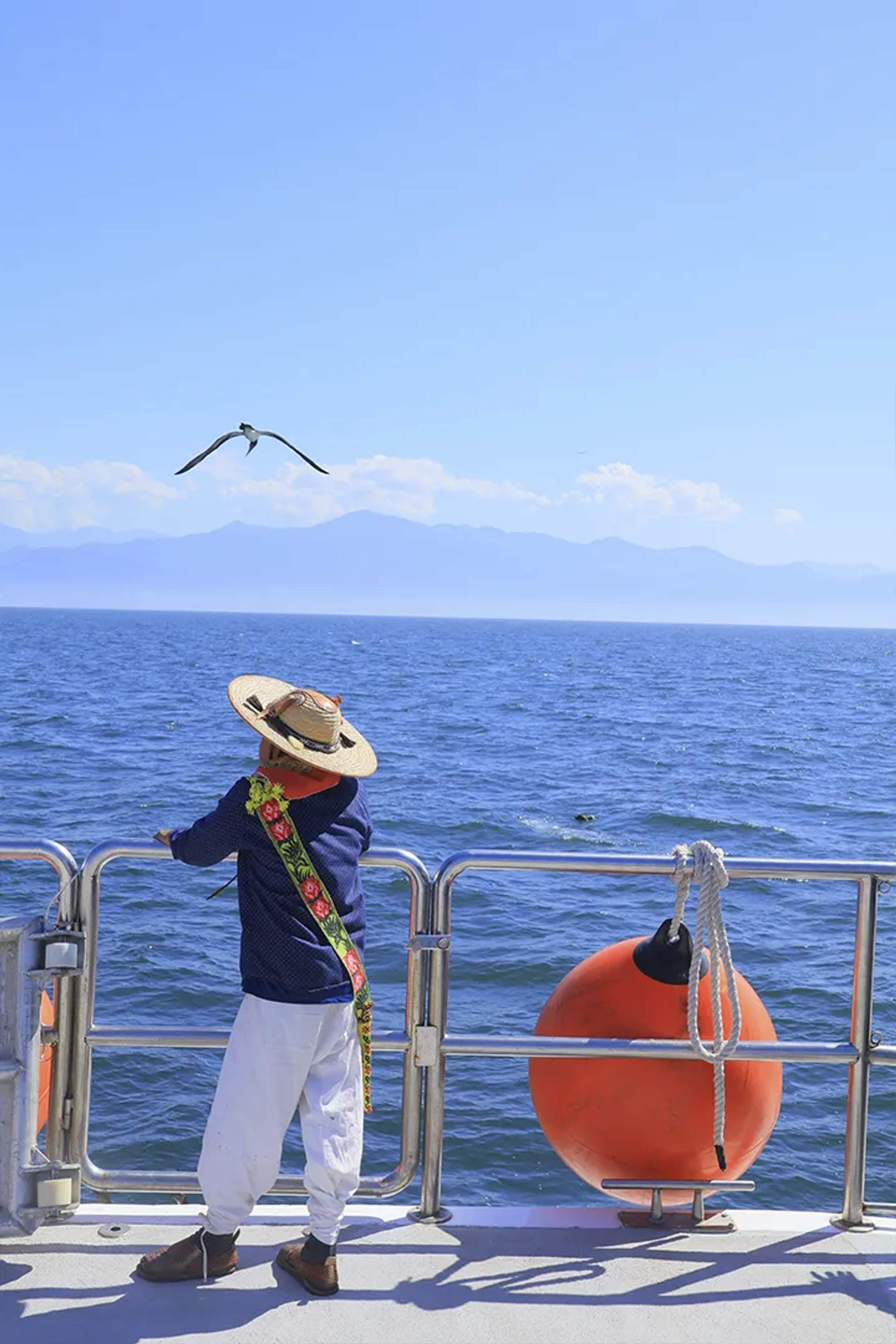 Niño huichol viendo al horizonte durante avistamiento de ballenas con Vallarta Adventures