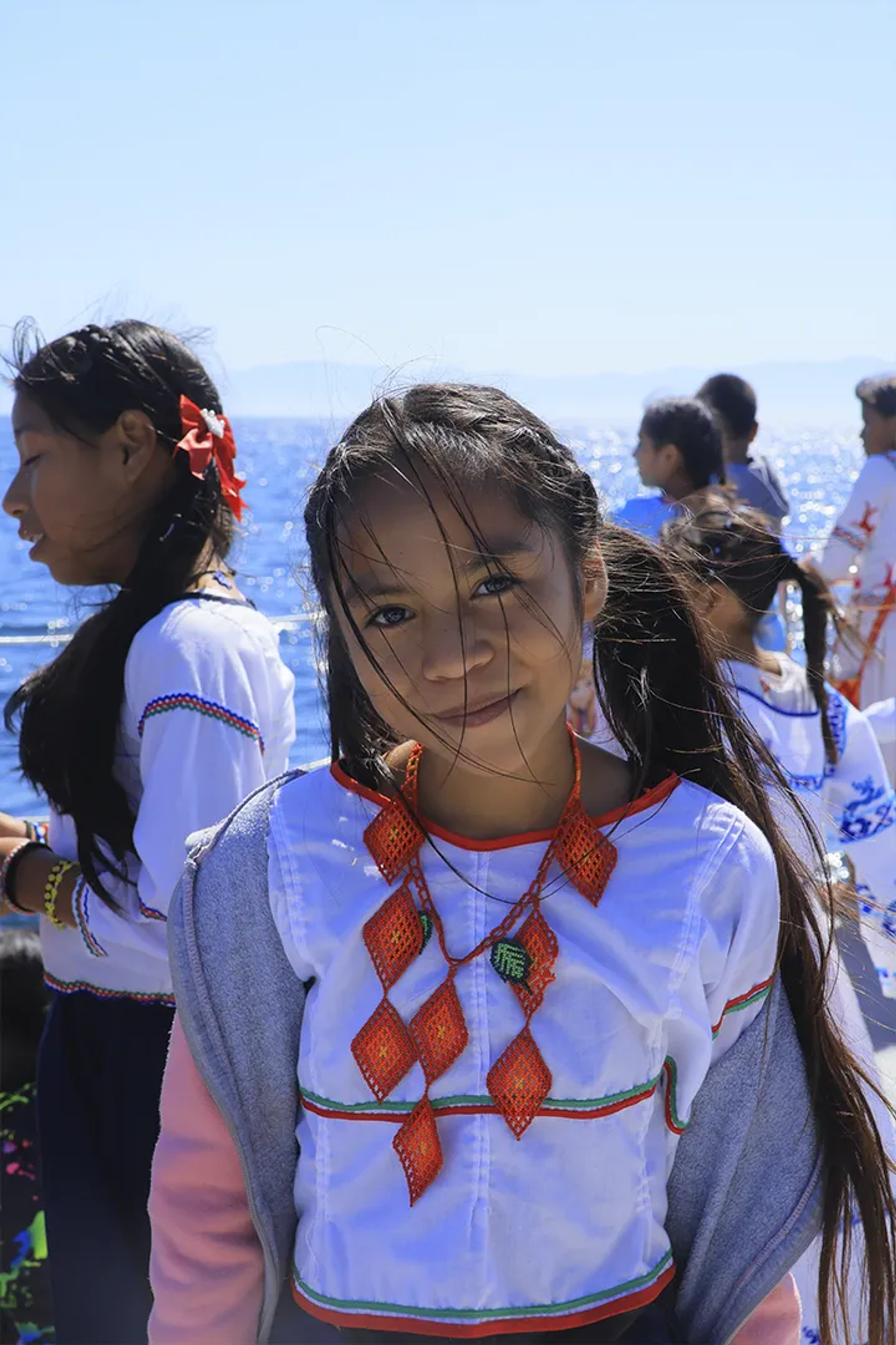 Niña con dos colitas y collar naranja 