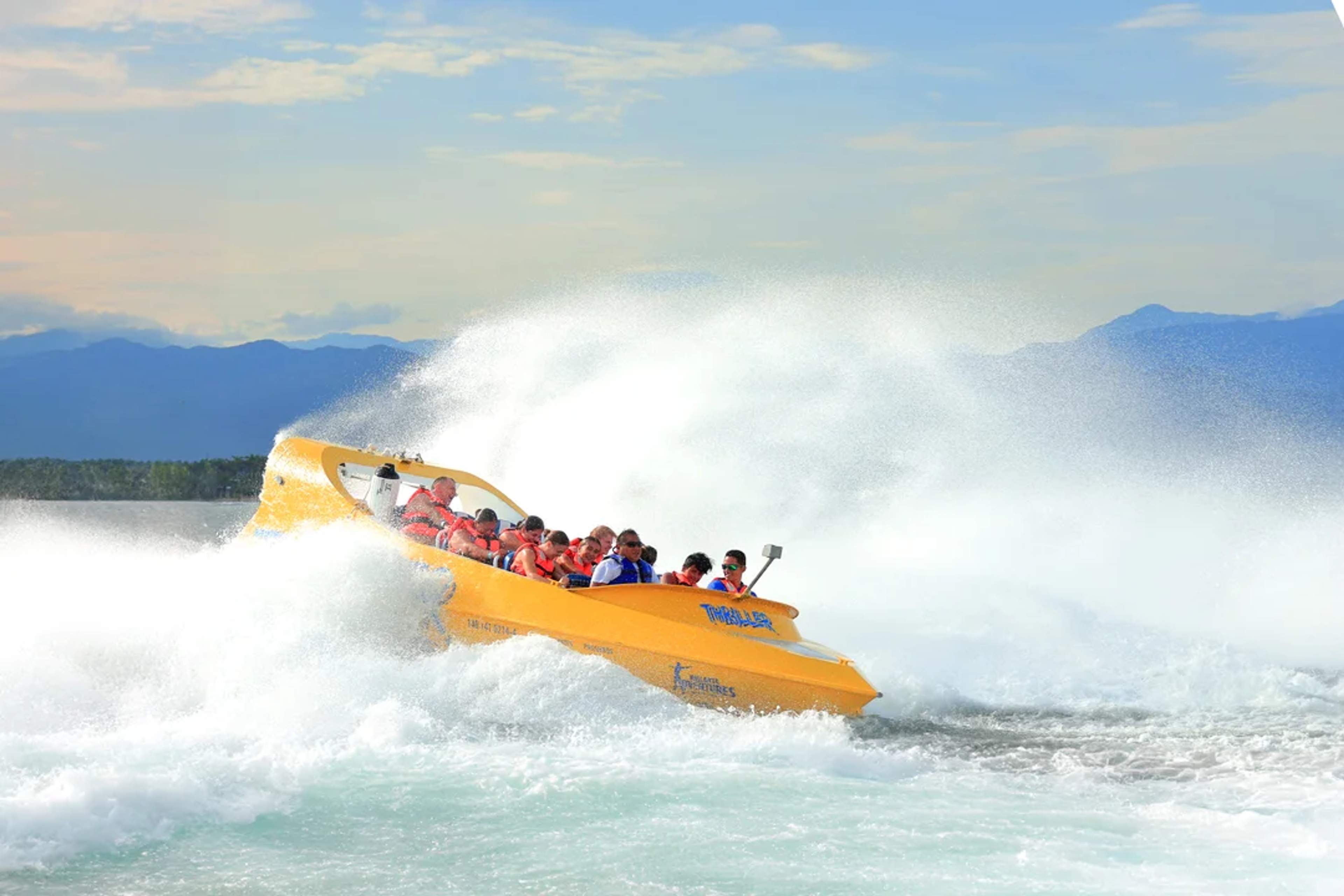 Amantes de la adrenalina disfrutan un paseo en lancha amarilla entre olas en Puerto Vallarta, México.